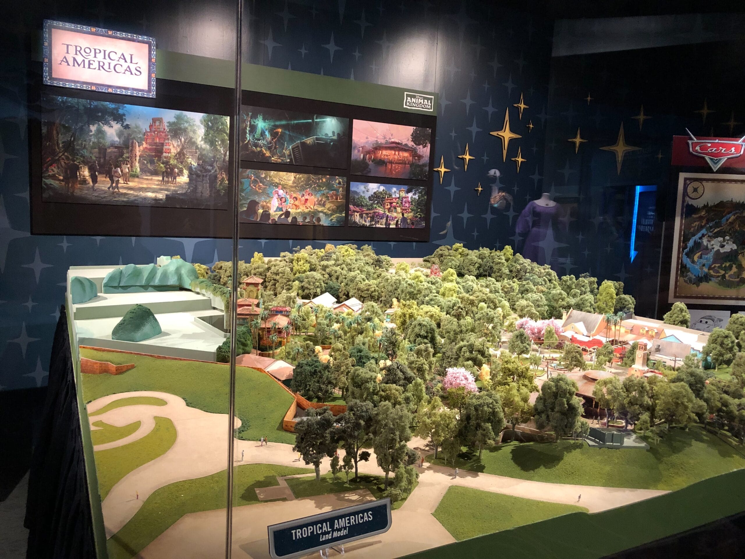 Model of “Tropical Americas” land with lush trees, themed buildings, and winding paths, in a style reminiscent of Animal Kingdom.