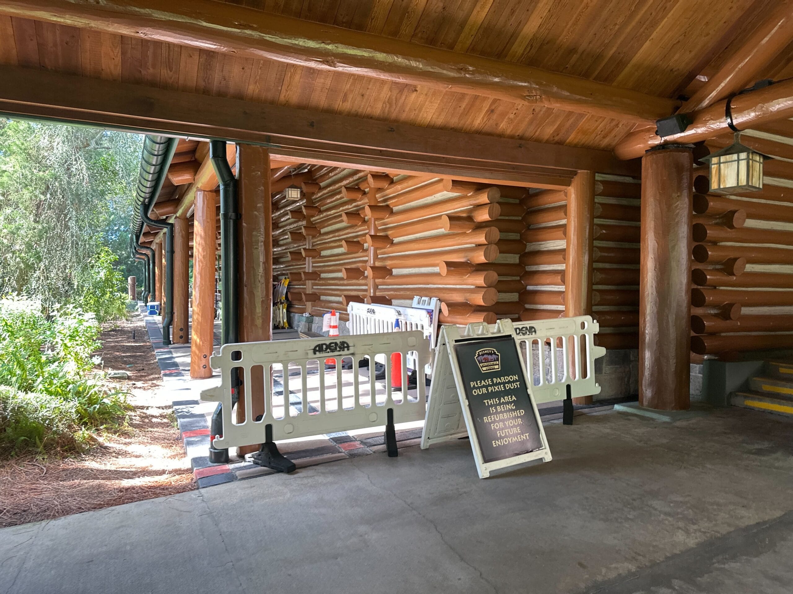 Log cabin at a Disney park with barriers and a closure sign, area off-limits for maintenance—no view of classic park castles here.