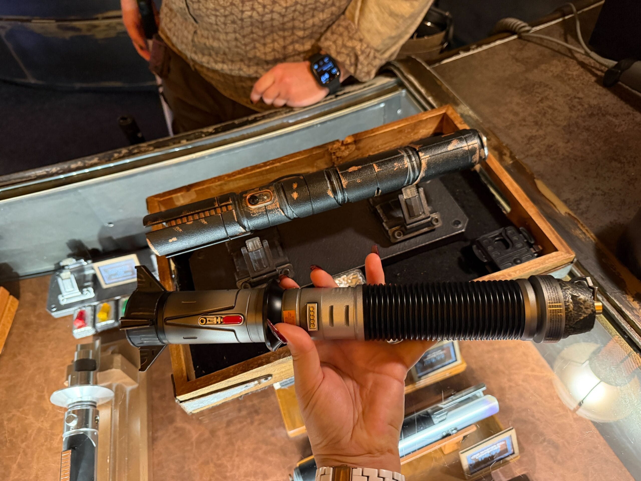 Stranger Saber being held and Baylan's Saber on stand at Dok's in Disney's Hollywood Studios