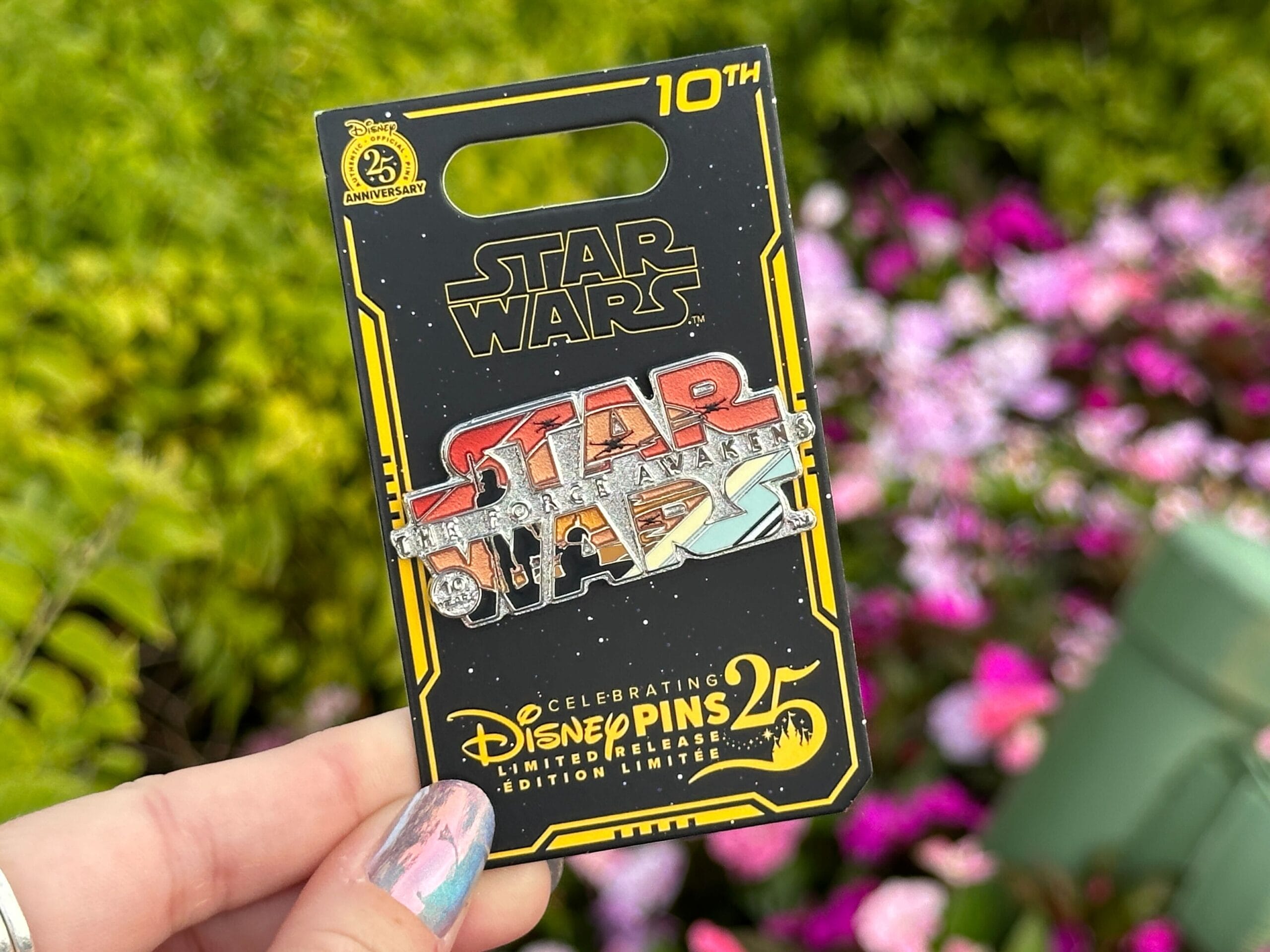 The limited release Force Awakens pin features the Jakku skyline with X-Wings and the silhouettes of Rey and BB-8, set within the letters of Star Wars.