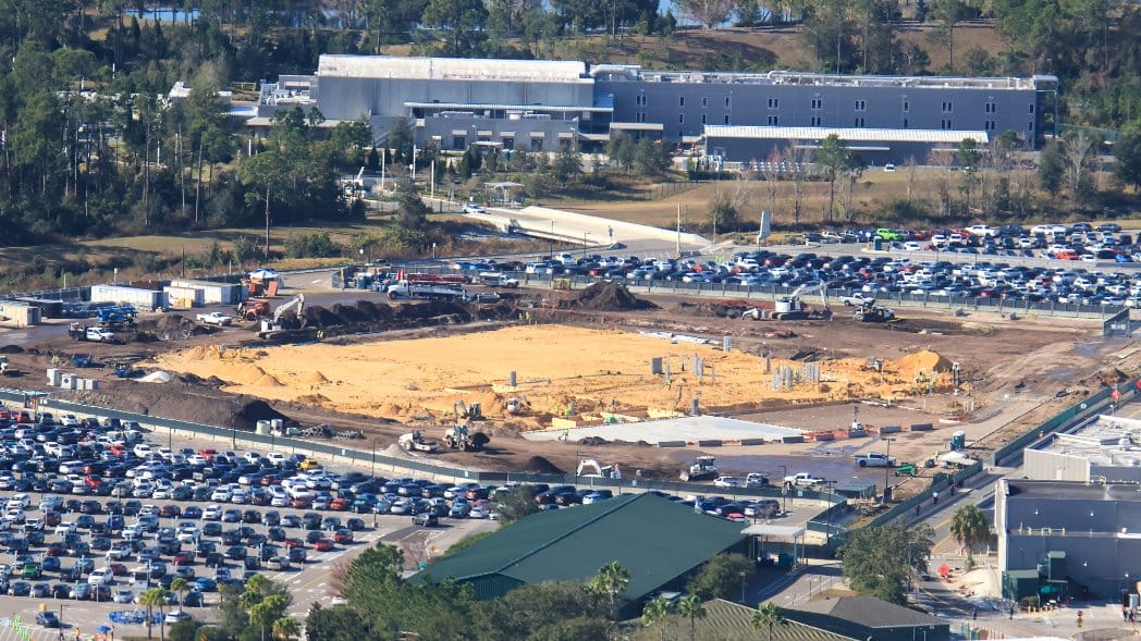 The gray utility conduits can be seen rising out of the sand at the far right of the sand plot. The building in the background is the former Star Wars: Galactic Starcruiser hotel, now being used as a Disney Imagineering office building.