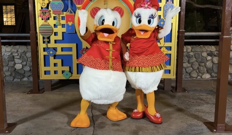 Donald and Daisy have matching Chinese-inspired red hanfu with gold designs, similar to Horace's outfit.
