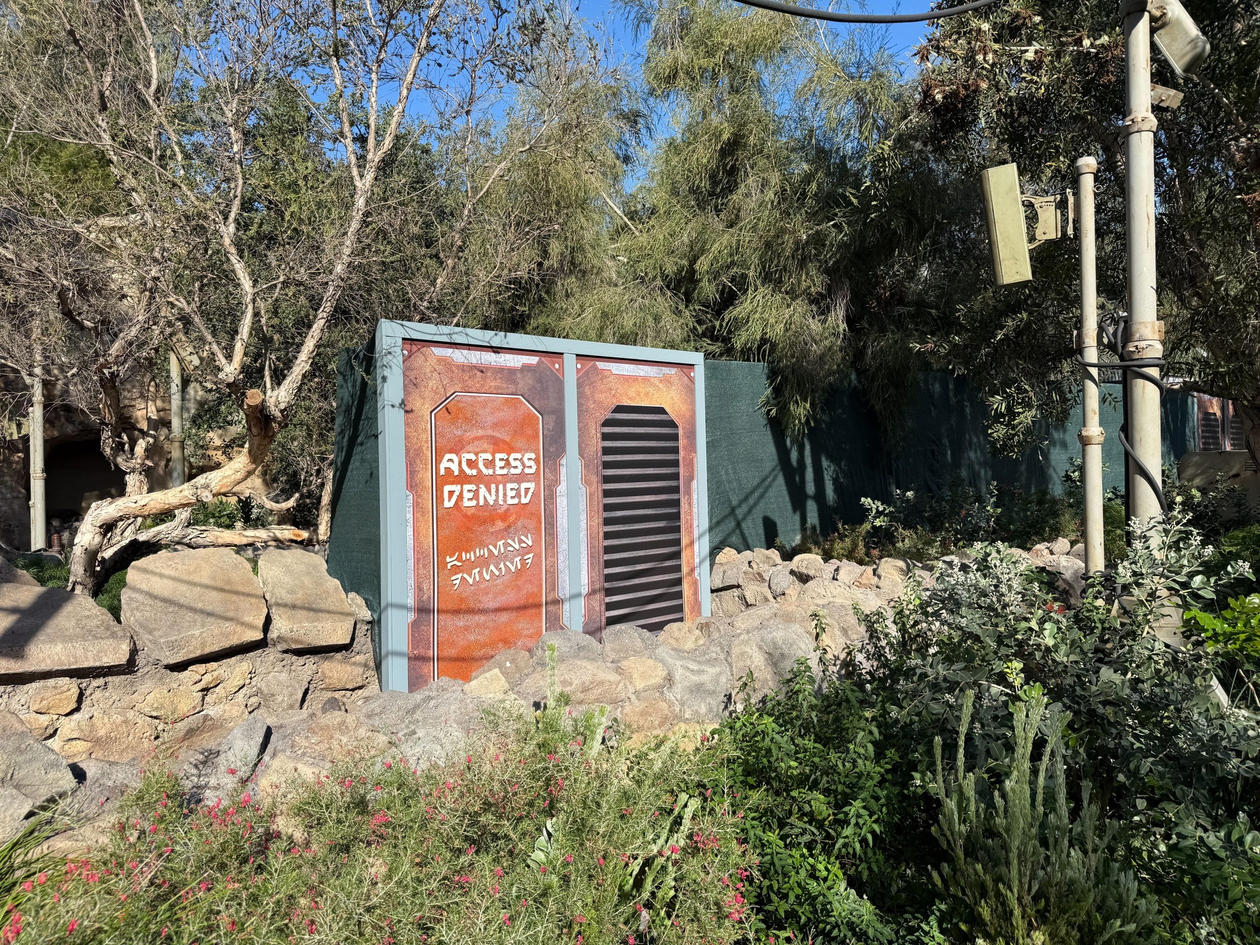 Various themed signs that read "Access Denied" block the access points to the attraction. Green scrim also surrounds the area.