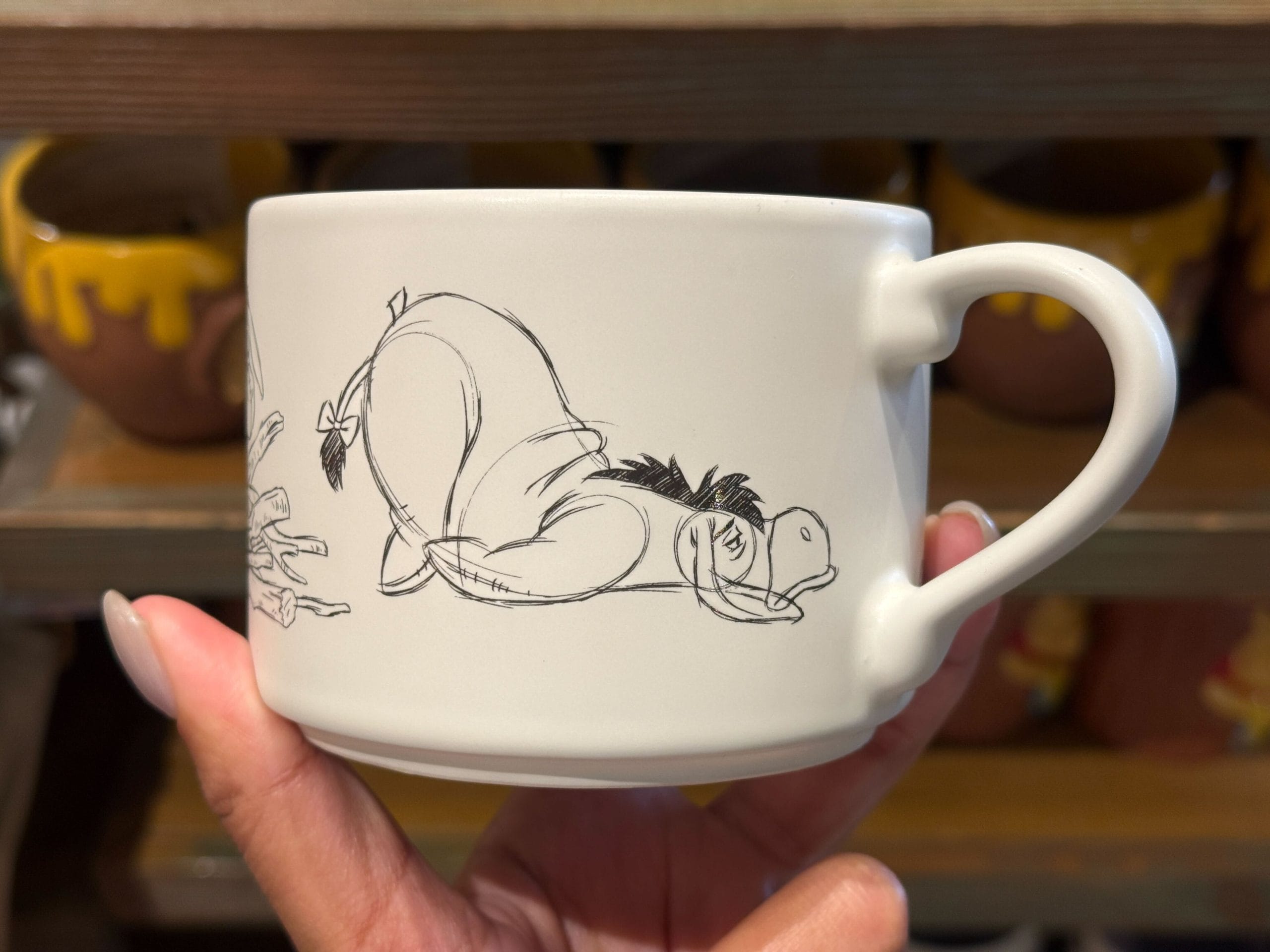 The Eeyore mug features him putting together his stick home, which then collapses around him. The interior is lavender.
