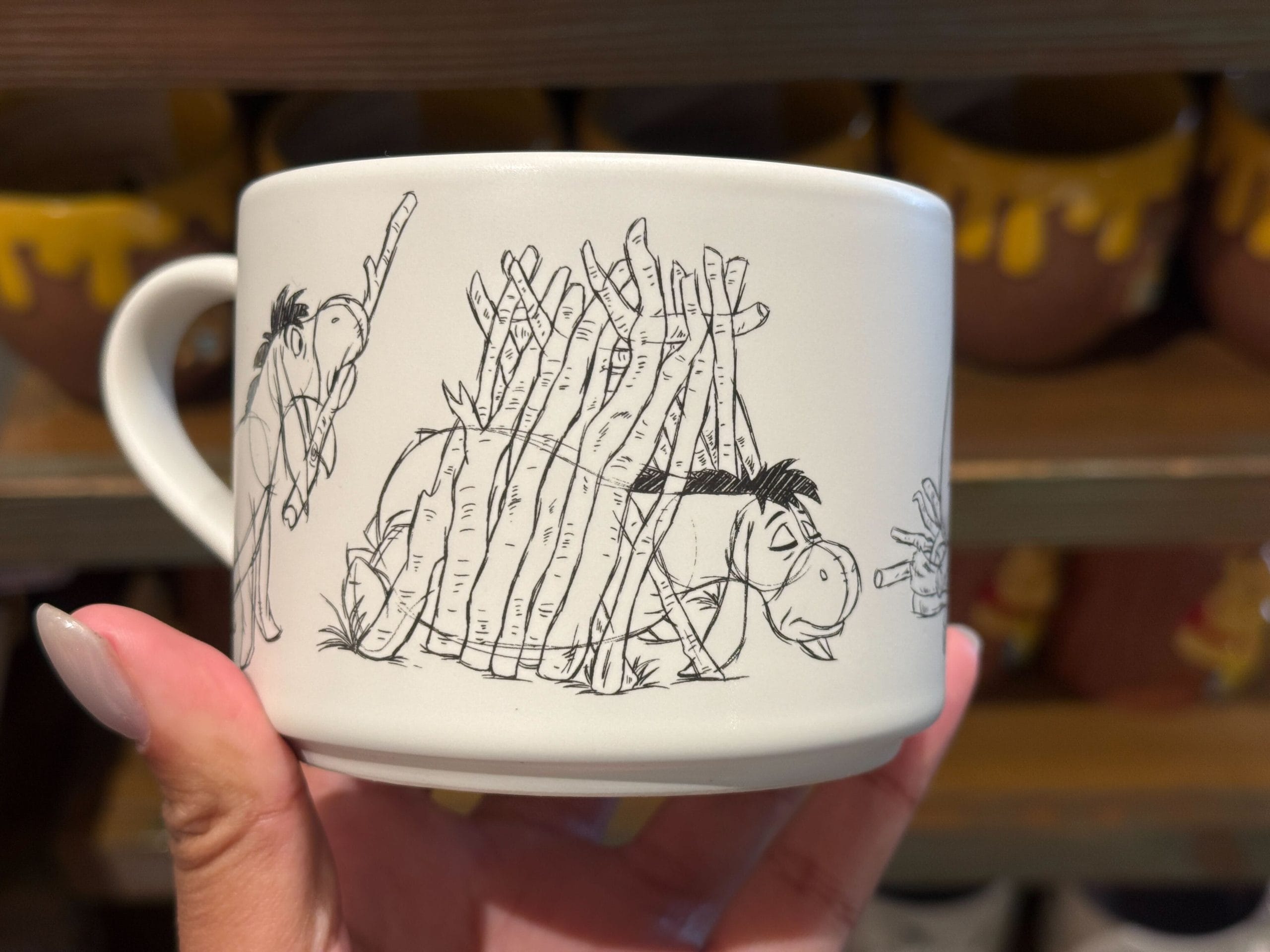 The Eeyore mug features him putting together his stick home, which then collapses around him. The interior is lavender.