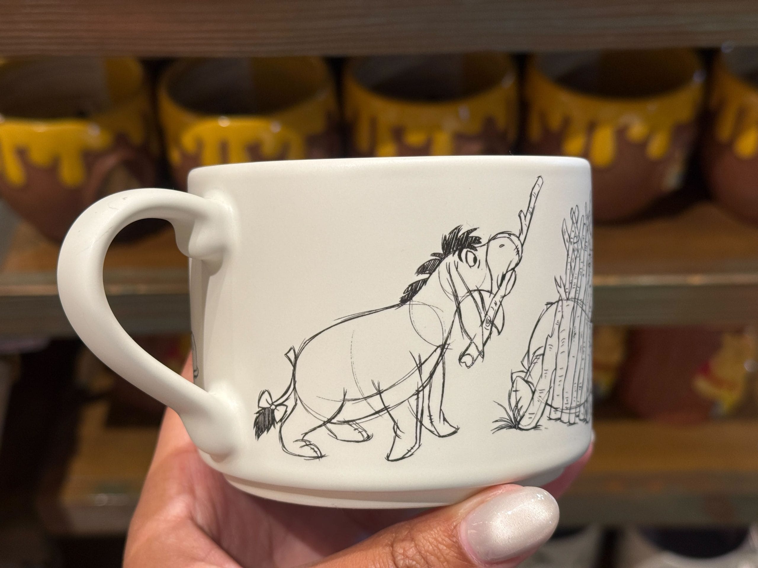 The Eeyore mug features him putting together his stick home, which then collapses around him. The interior is lavender.