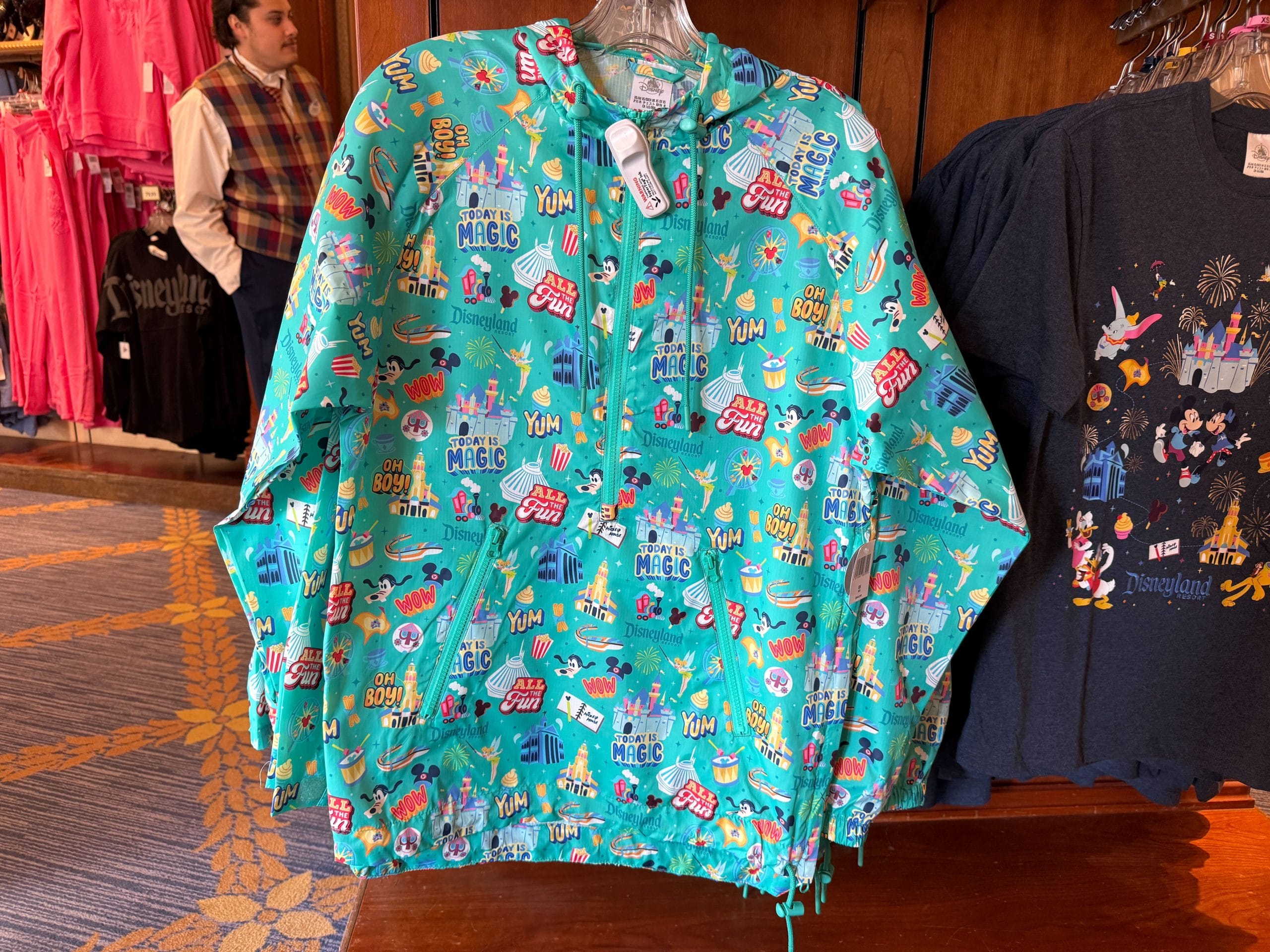 This aqua-colored windbreaker is a pullover with a half-zipper. It's packable thanks to a zip pouch on the back. On the front are two zip pockets. The hood and hem are drawstring.