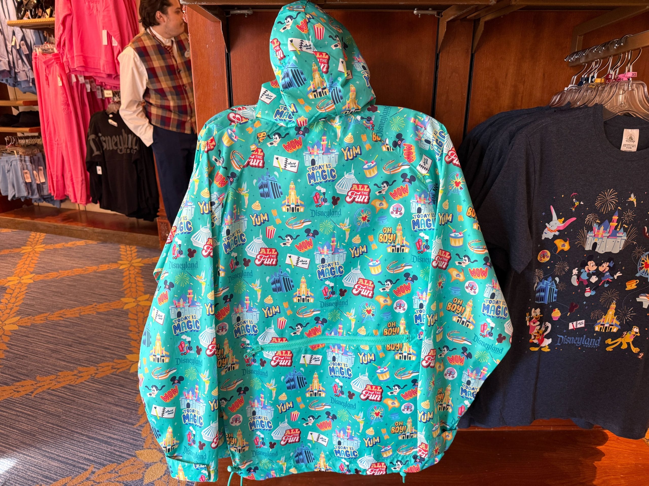 This aqua-colored windbreaker is a pullover with a half-zipper. It's packable thanks to a zip pouch on the back. On the front are two zip pockets. The hood and hem are drawstring.