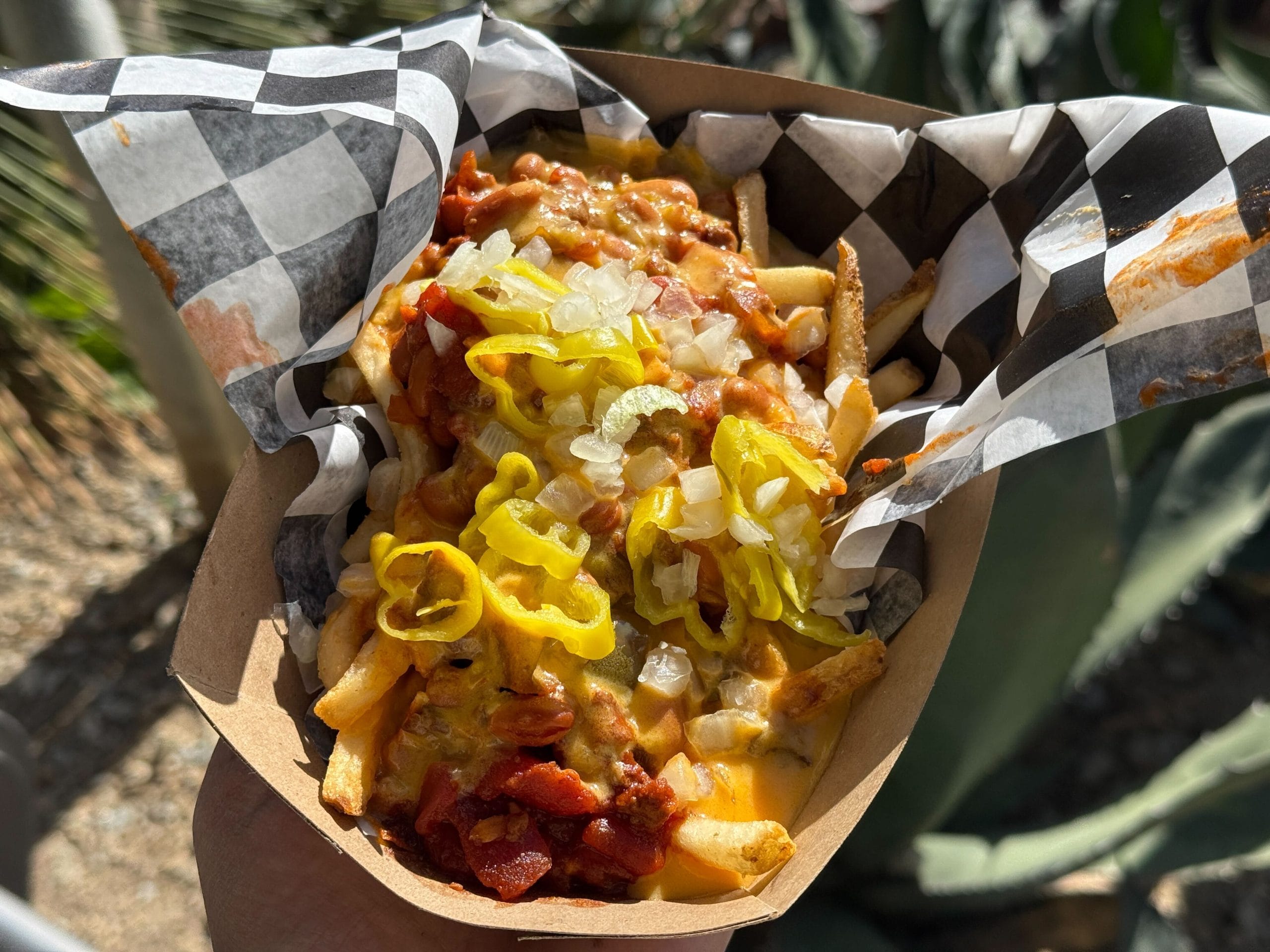 Fries topped with hearty chili, pepperoncini cheese sauce, sliced pepperoncini, and diced onions