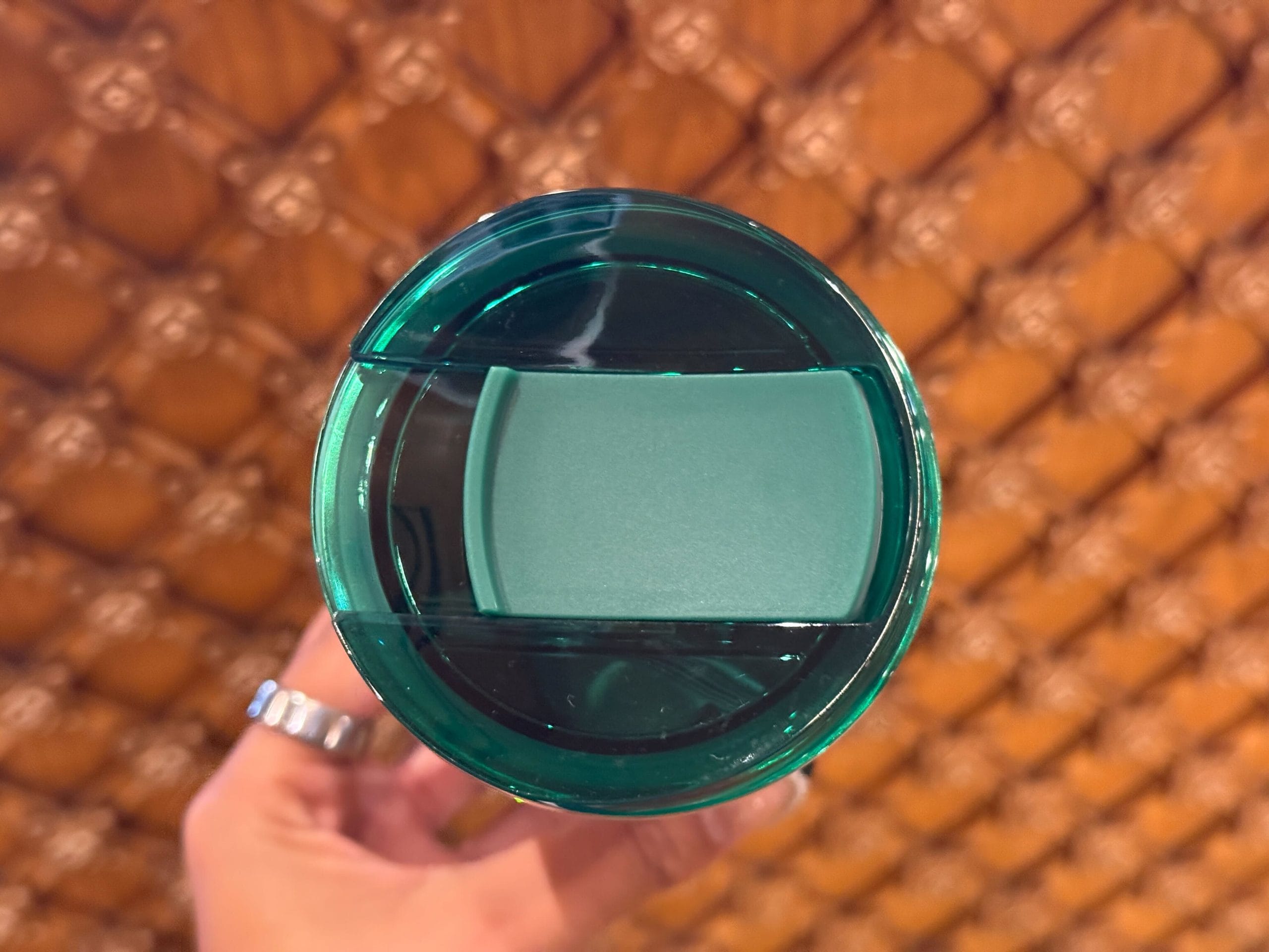 On top of the tumbler is a lid with a slide-open mouthpiece. The back of the tumbler features the Starbucks logo.
