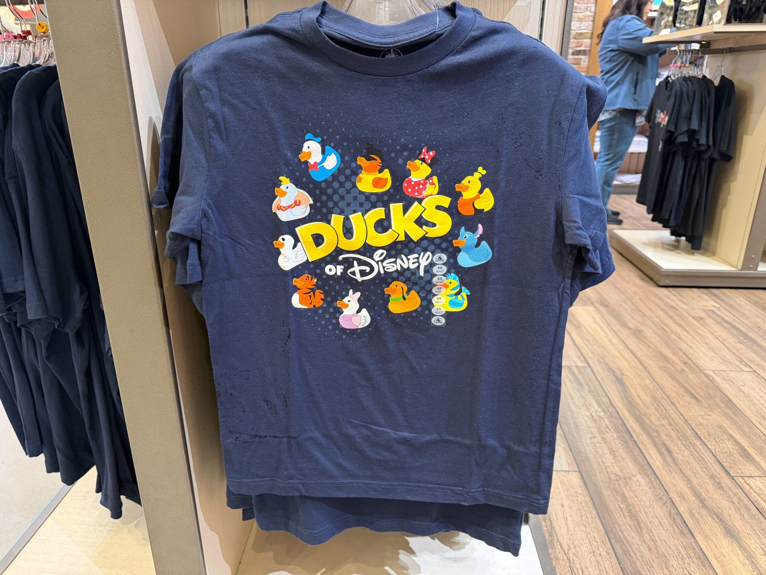 Navy "Ducks of Disney" shirt with images of different Disney characters as rubber ducks