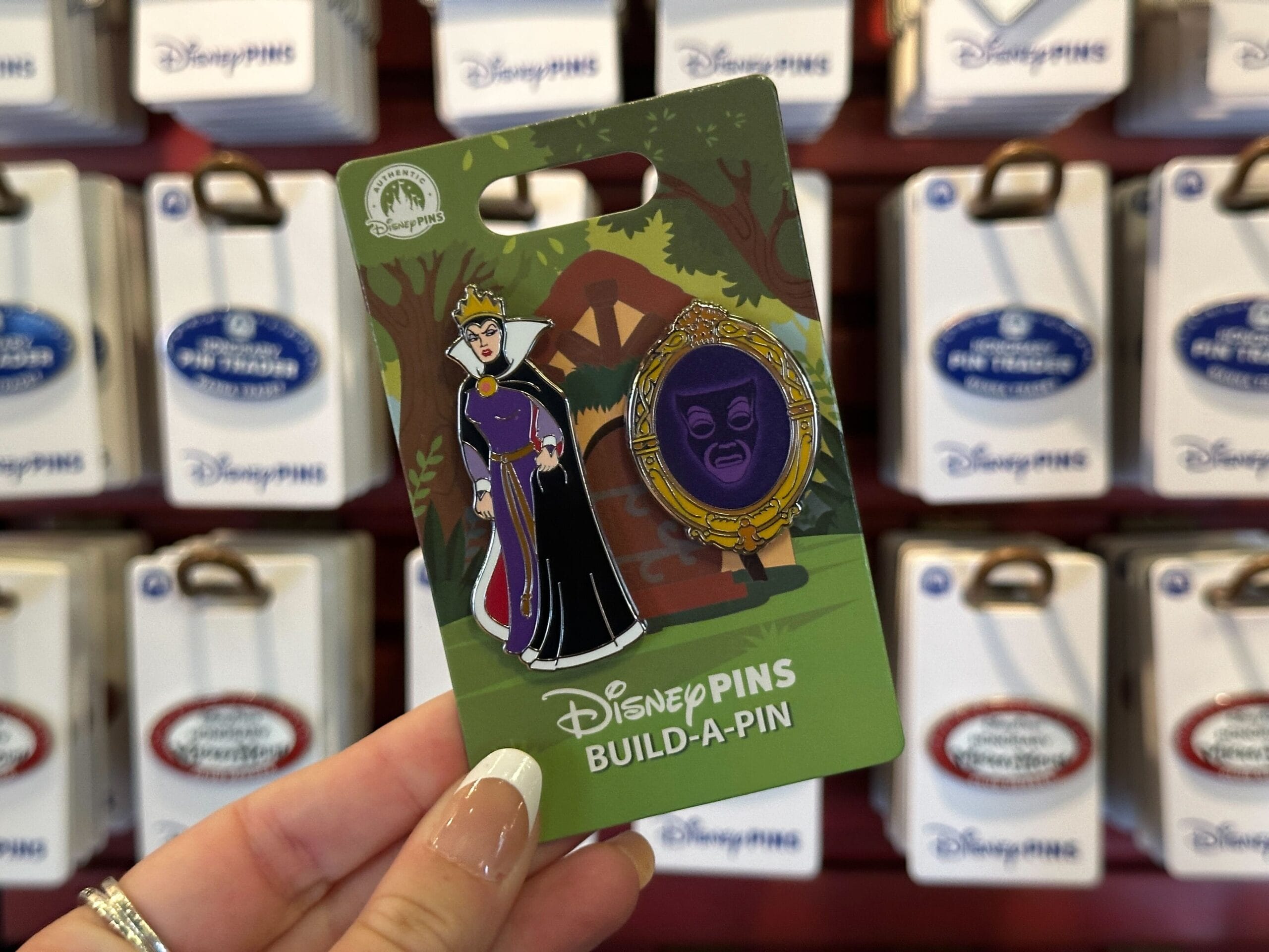 This build-a-pin set comes with the Evil Queen and her talking Magic Mirror. They can be attached to a base pin (such as the cabin image shown behind them), but this set does not come with the base.