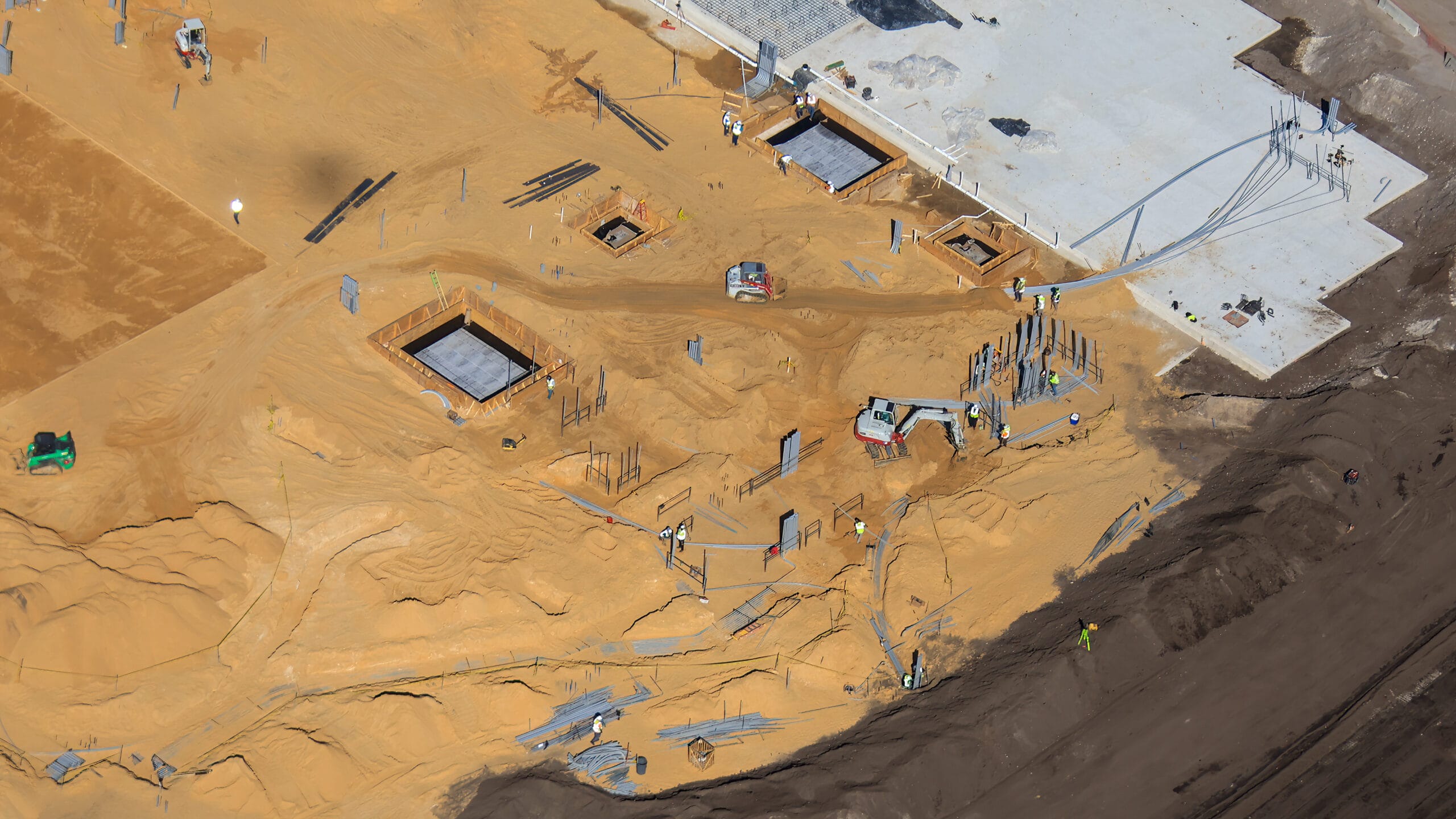 Here we can see more electrical conduits being buried in the sand from two different angles.