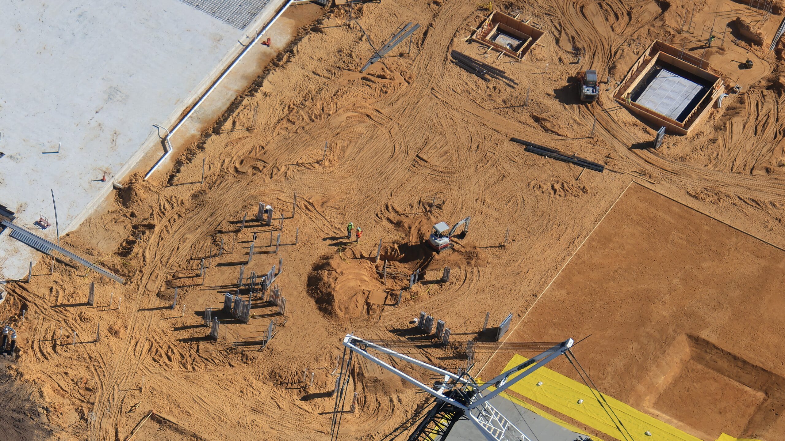 Here we can see more electrical conduits being buried in the sand from two different angles.