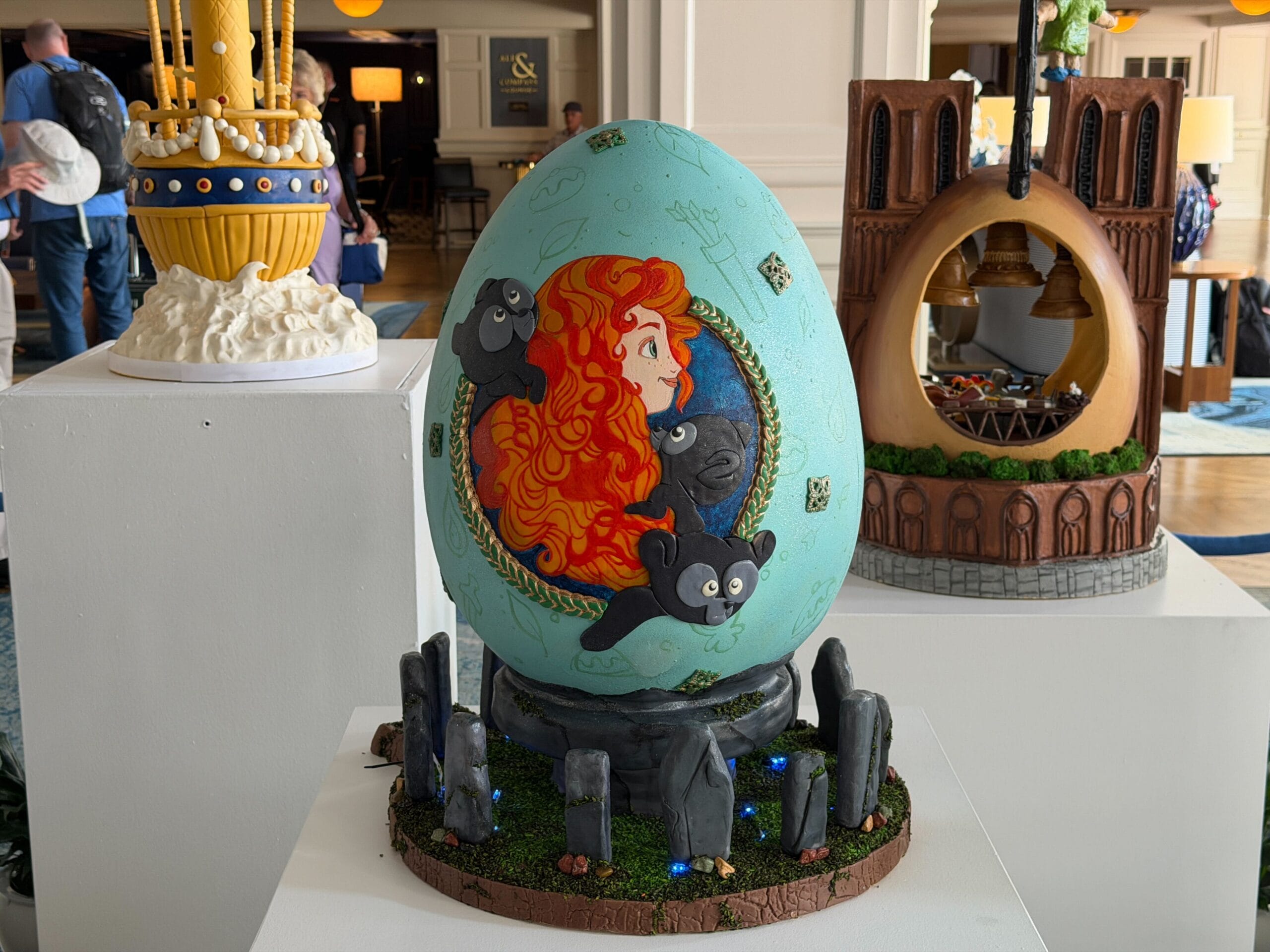The last egg is inspired by Pixar's 'Brave.' Merida is featured in the display with the three bear cubs, while the blue egg is surrounded by the standing stones from the film. Lights have been put in the base of the display.