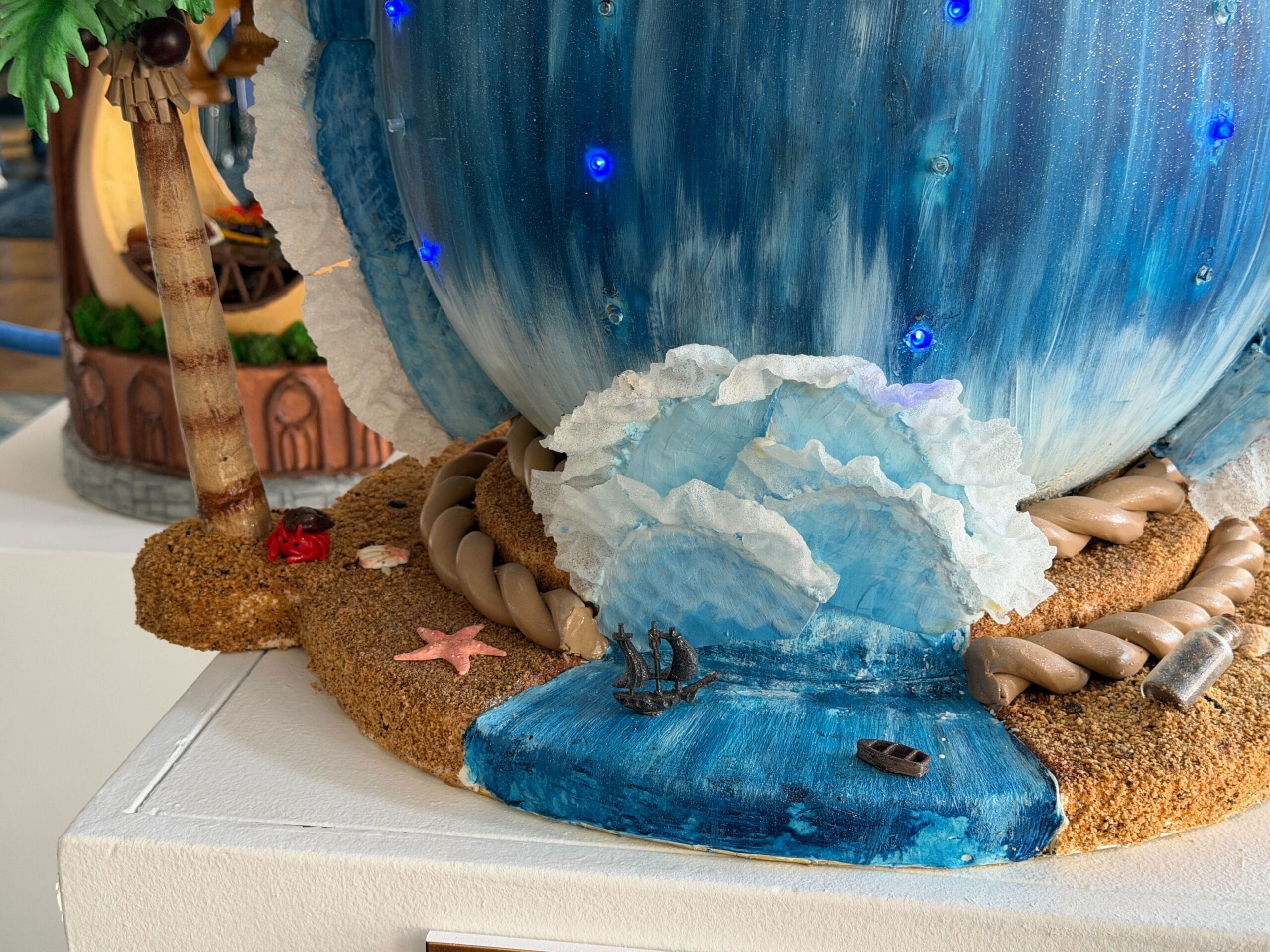 The fifth egg is inspired by Pirates of the Caribbean: At World's End, namely the scene where they go over the edge of the world. The egg is decorated as the ocean, as the Black Pearl sails on top of it. Lights are present inside the egg.