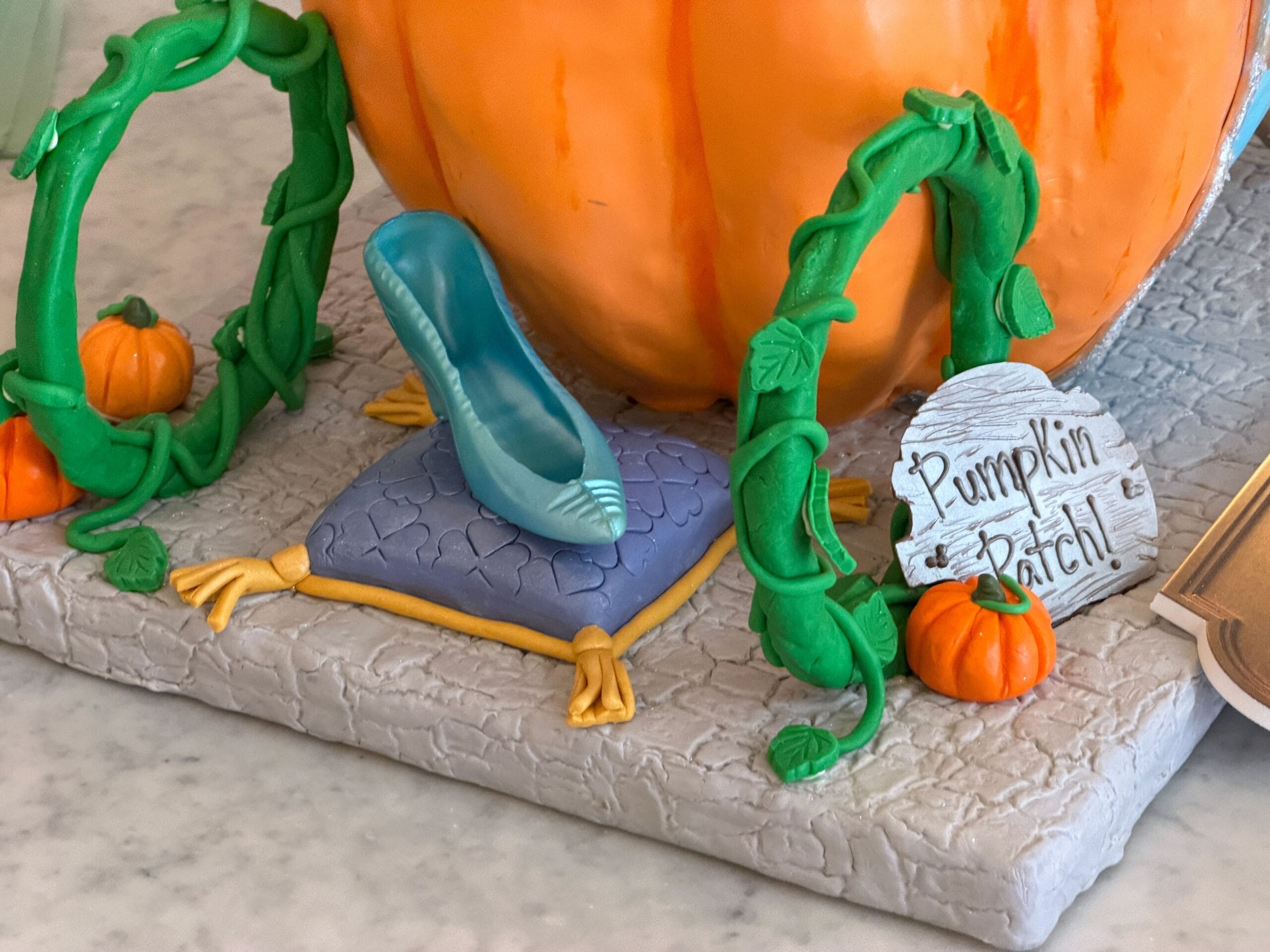 Jaqcues, Gus, and Mary, the mice from the film, as they are reading the book from which they make Cinderella's dress. Bibbity Bobbity Boo! is written on the ground, while another sign reads Pumpkin Patch! next to the glass slipper sitting on a pillow.