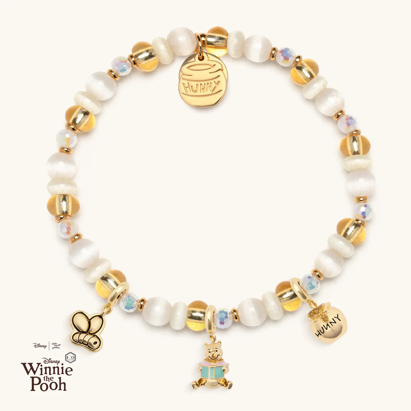 This charm bracelet offers a subtle touch of Pooh with three non-removable charms (the same as the individual charms seen above). It comes in several sizes and is adorned with ivory, gold, and translucent beads throughout.