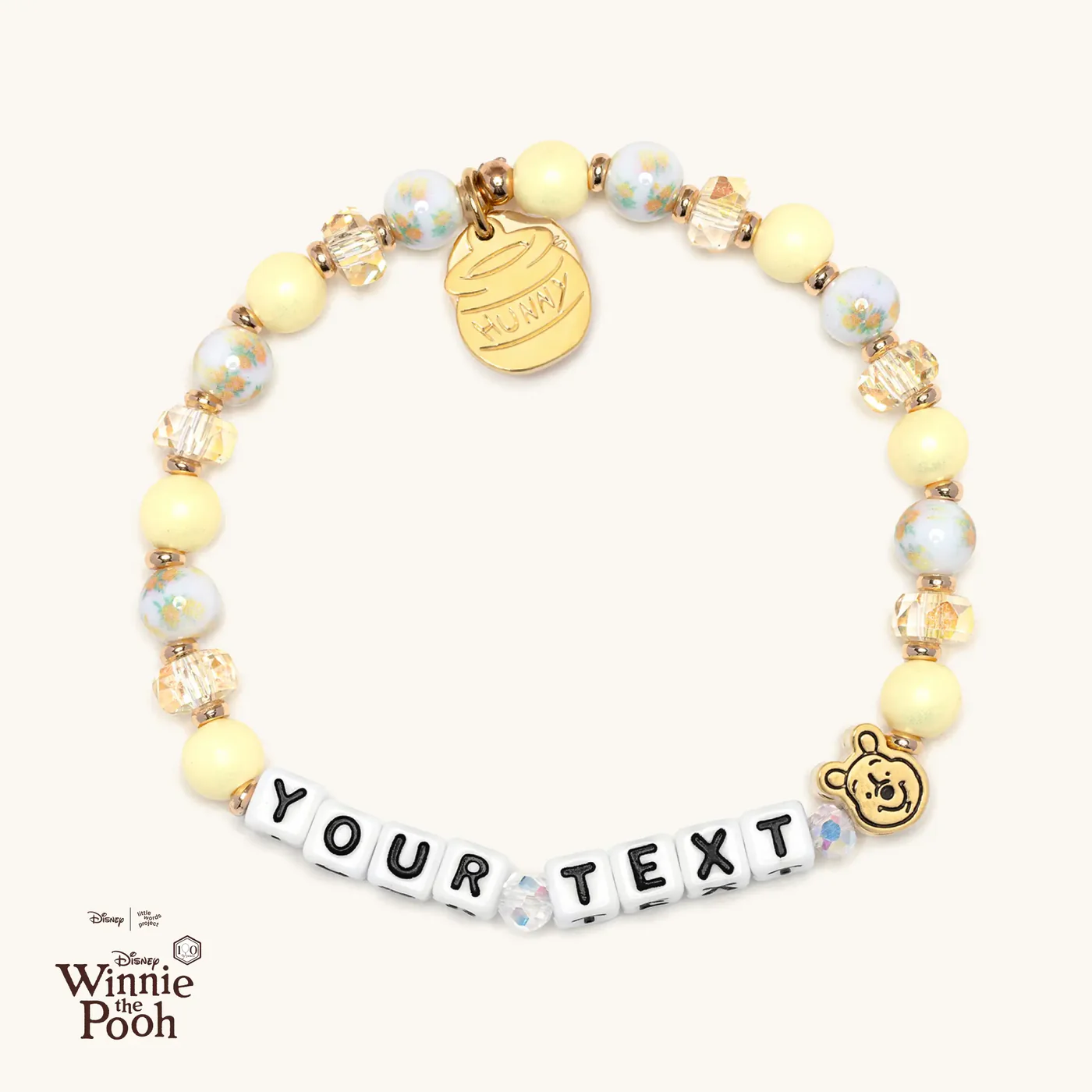 This bracelet is customizable. It has space for your text in block letters with a gold Pooh bead on one end. At the back of the bracelet is a dangling "Hunny" pot charm.