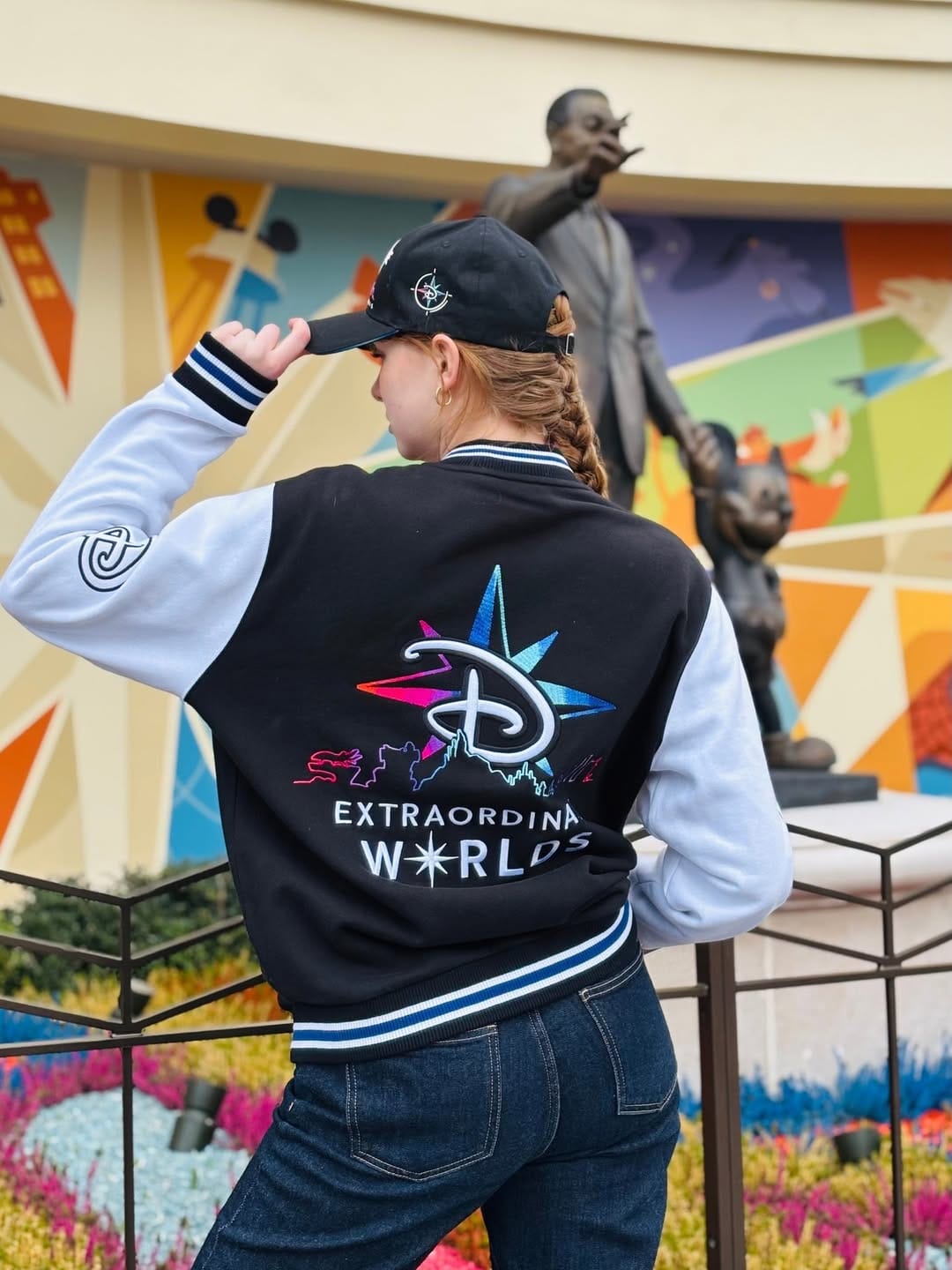 A varsity-style jacket is also available. It has a black body and white sleeves. On the back is the Disney Adventure World logo, and a Disney "D" is on the left sleeve. A black hat will also be available with the same "D" surrounded by compass points as seen on the back of the jacket.