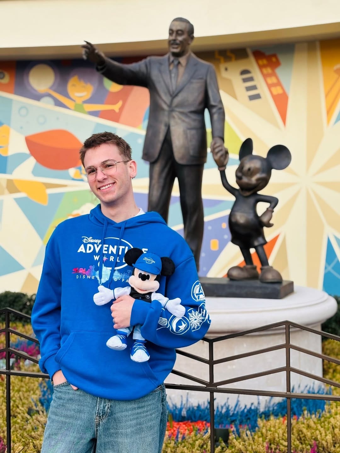 One of the new items includes a blue hooded sweatshirt with the Disney Adventure World logo on the front and areas of the park on the sleeve. There is also a plush Mickey Mouse dressed in similar park gear.