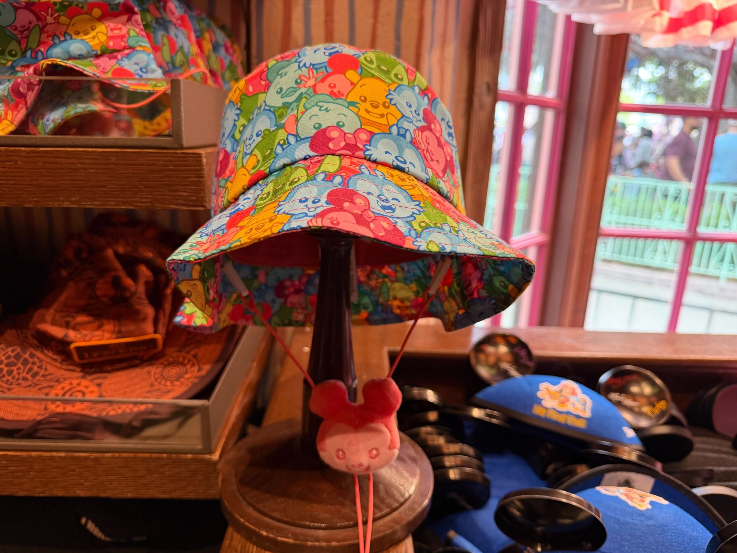 This bucket hat is patterned with cutesy, colorful images of Mickey, Minnie, Chip 'n' Dale, Stitch, Winnie the Pooh, and Donald Duck.