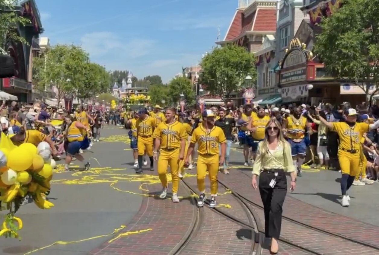 Players dressed in their yellow Savannah Bananas uniforms then walk alongside the Disneyland Fire Engine.
