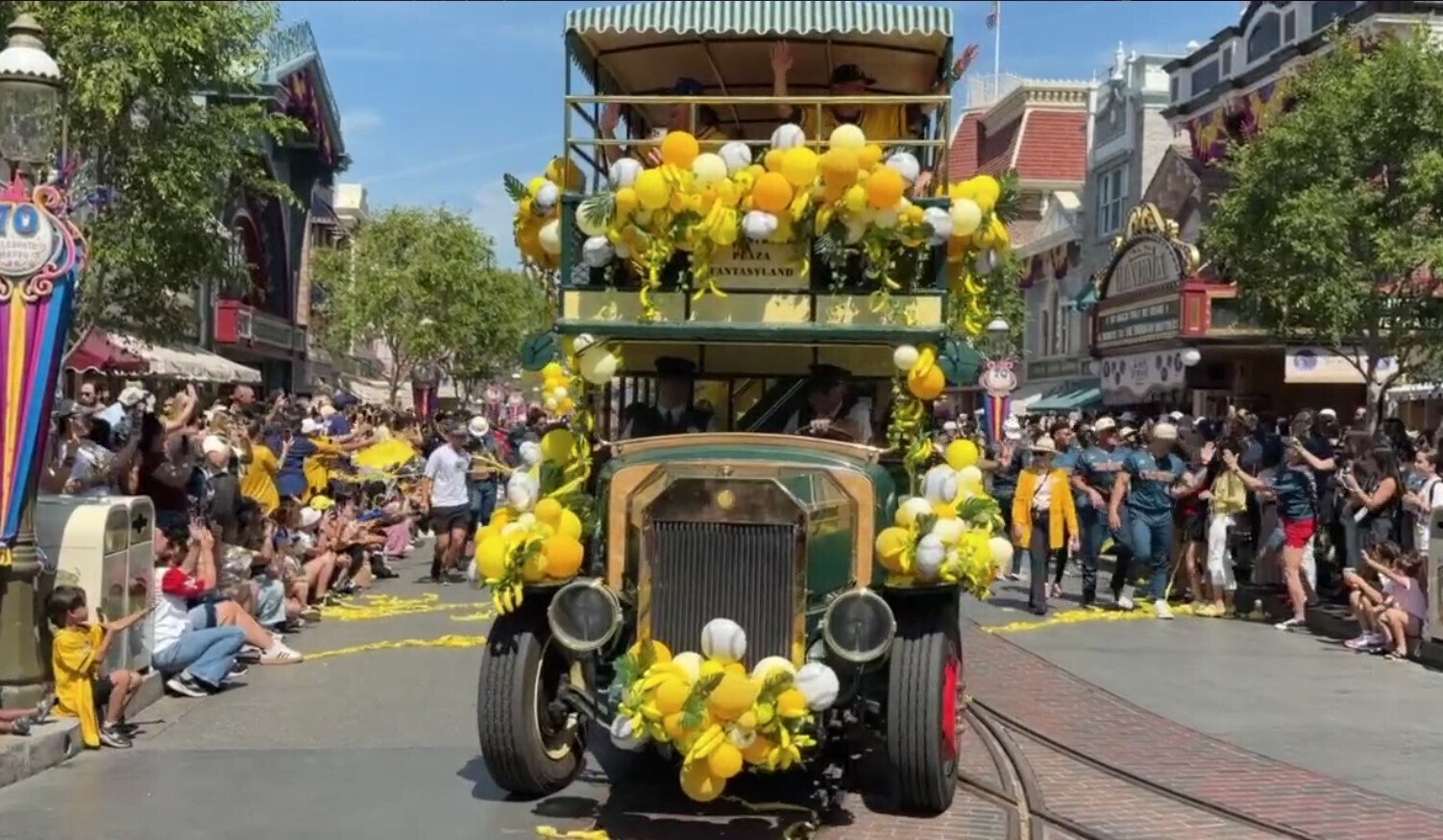 The cavalcade concludes with players waving and cheering from the Disneyland Omnibus while players from the Indianapolis Clowns walk behind them.