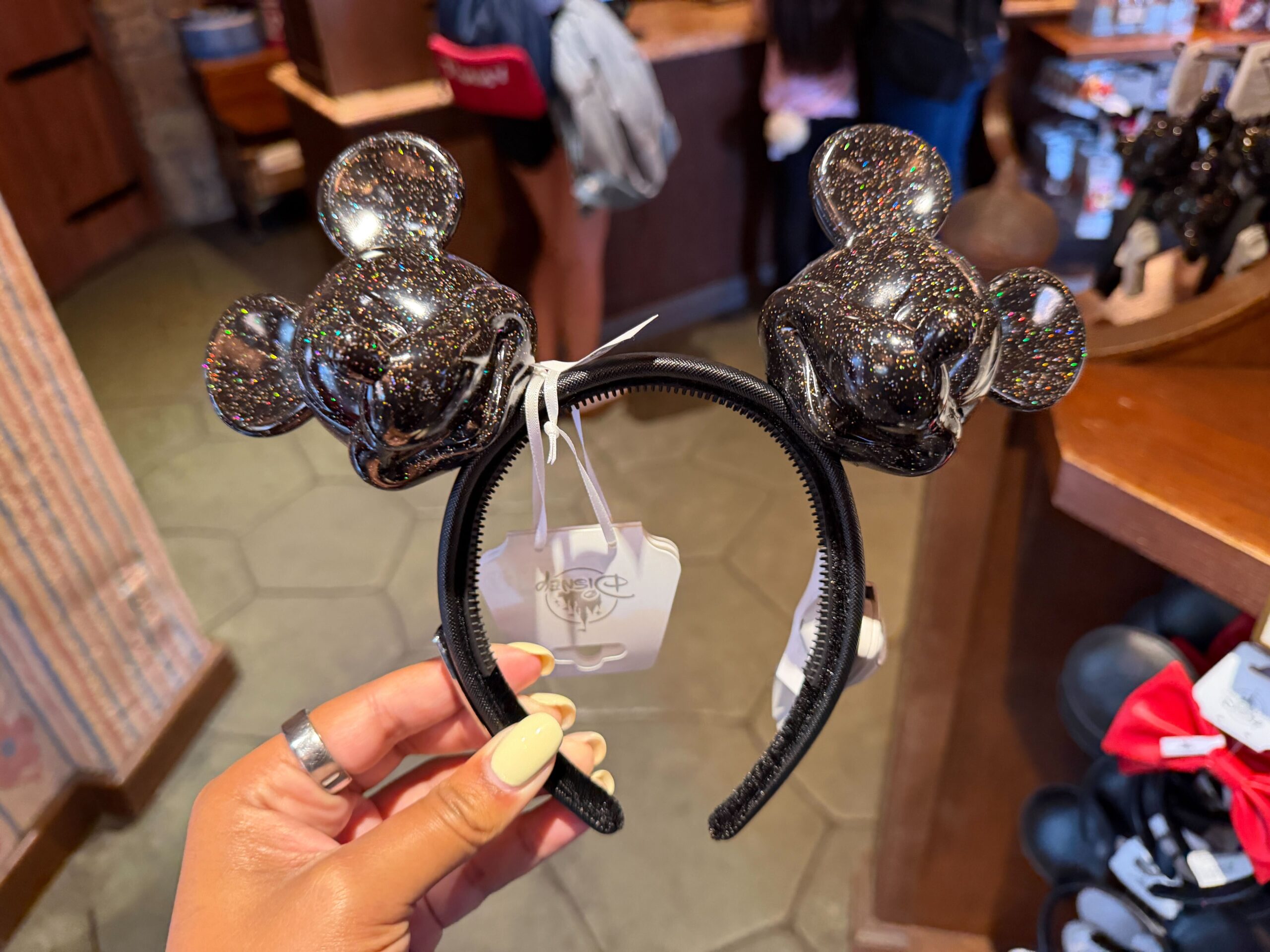 The "ears" on this headband are actually molded Mickey heads. They're black with a glitter finish. The headband has plastic teeth on the inside along with velour lining.