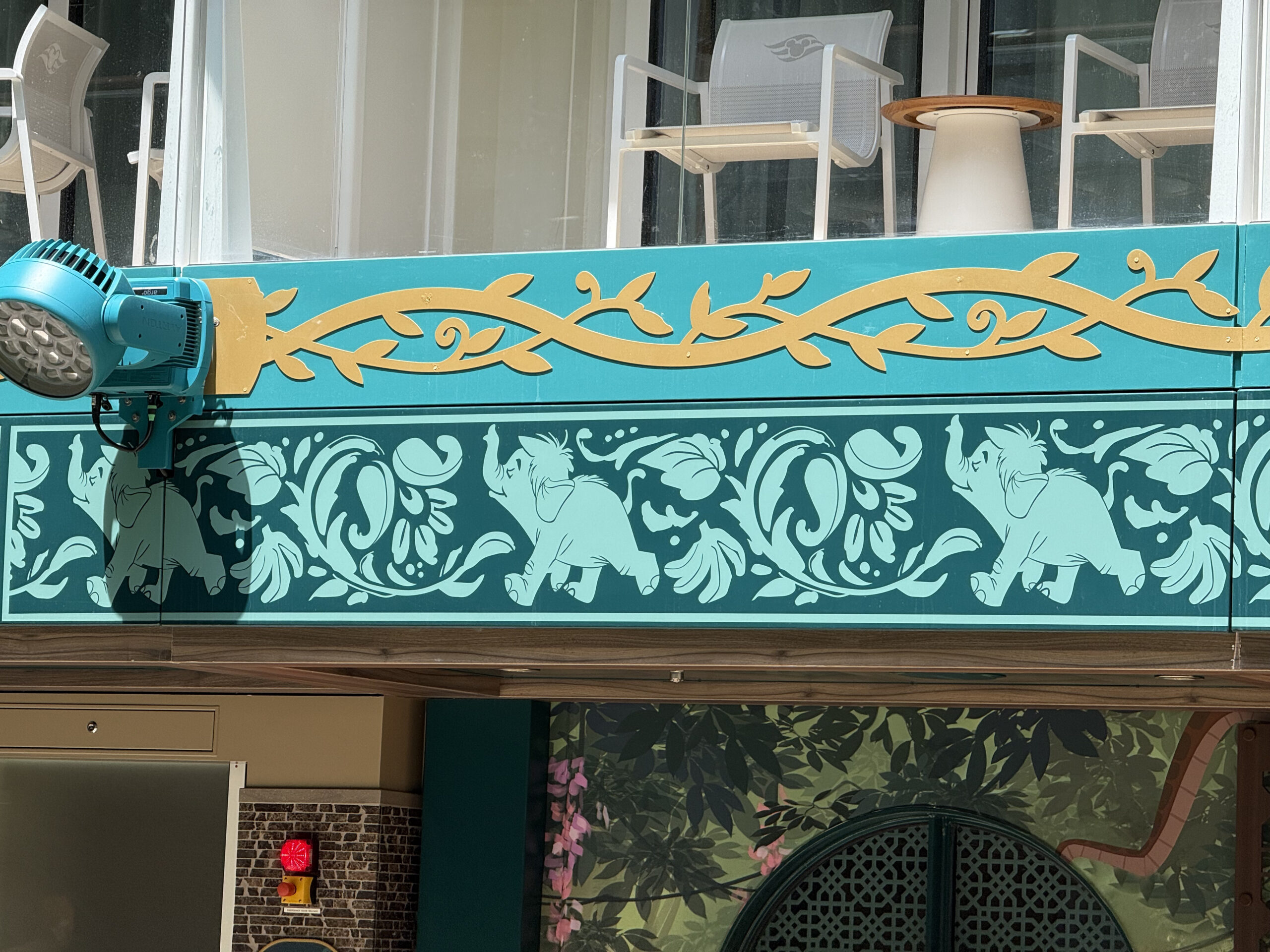 Sitting just below garden-facing cabin balconies, a teal and turquoise pattern runs across the front of the restaurant. It features floral patterns and Hathi Jr., the elephant, marching proudly.