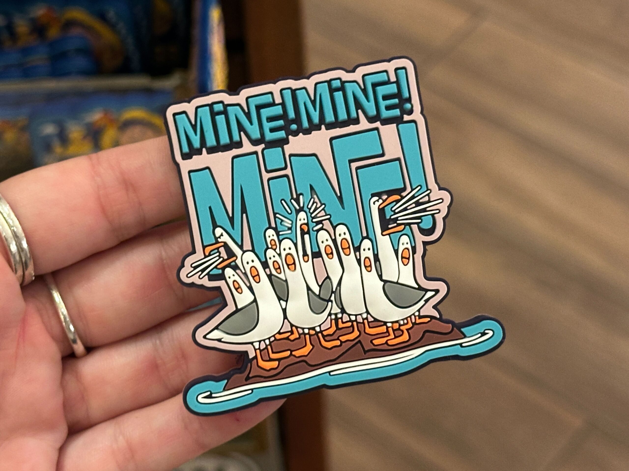The pack of seagulls from Finding Nemo is back, screaming their iconic "Mine! Mine! Mine!" phrase. On this magnet, we see the squawking birds beneath oversized blue letters spelling out their well-known phrase.
