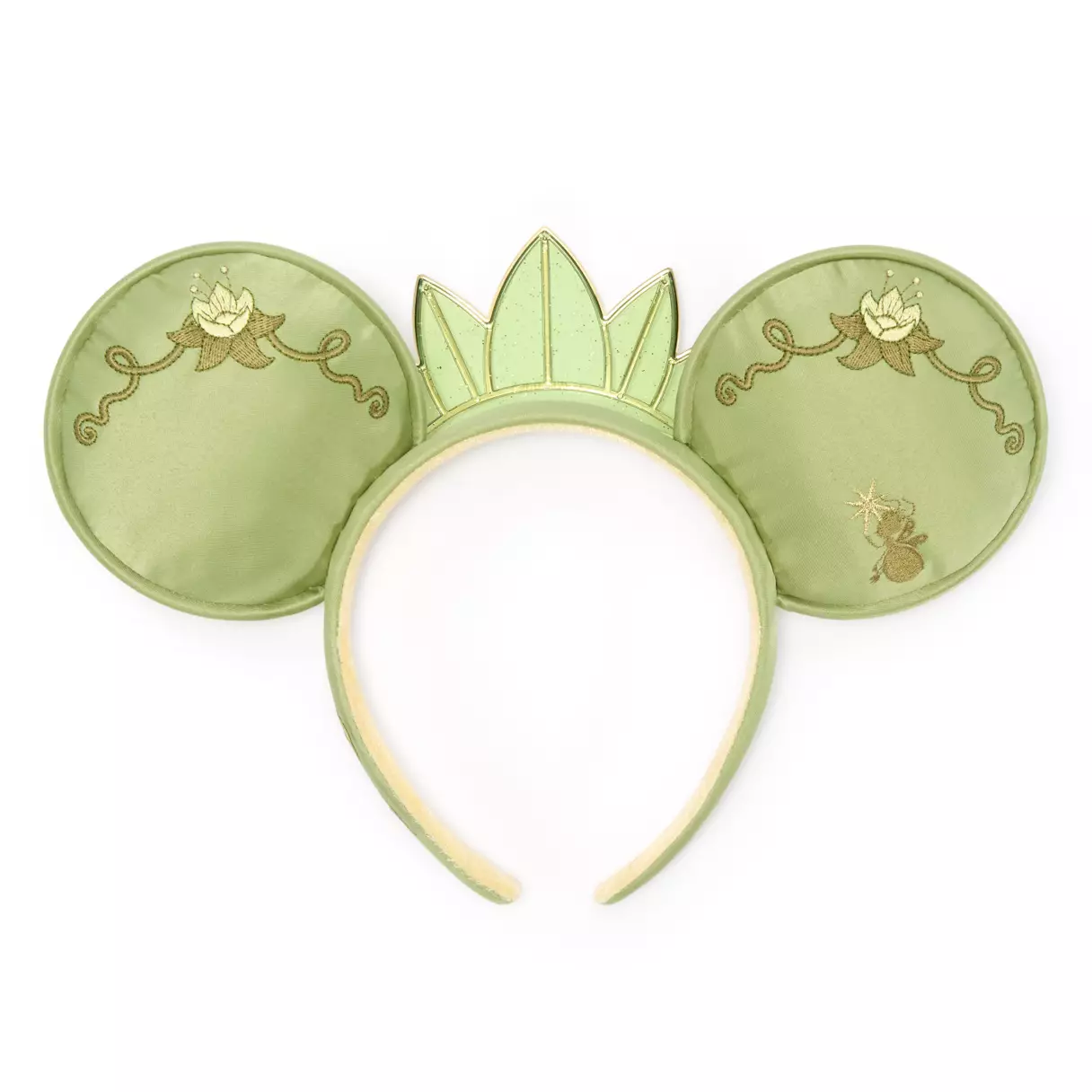In the center of the headband is a green translucent, sparkly tiara just like Tiana's. More embroidered filigree is on the back of each ear, including embroidered lily pads.