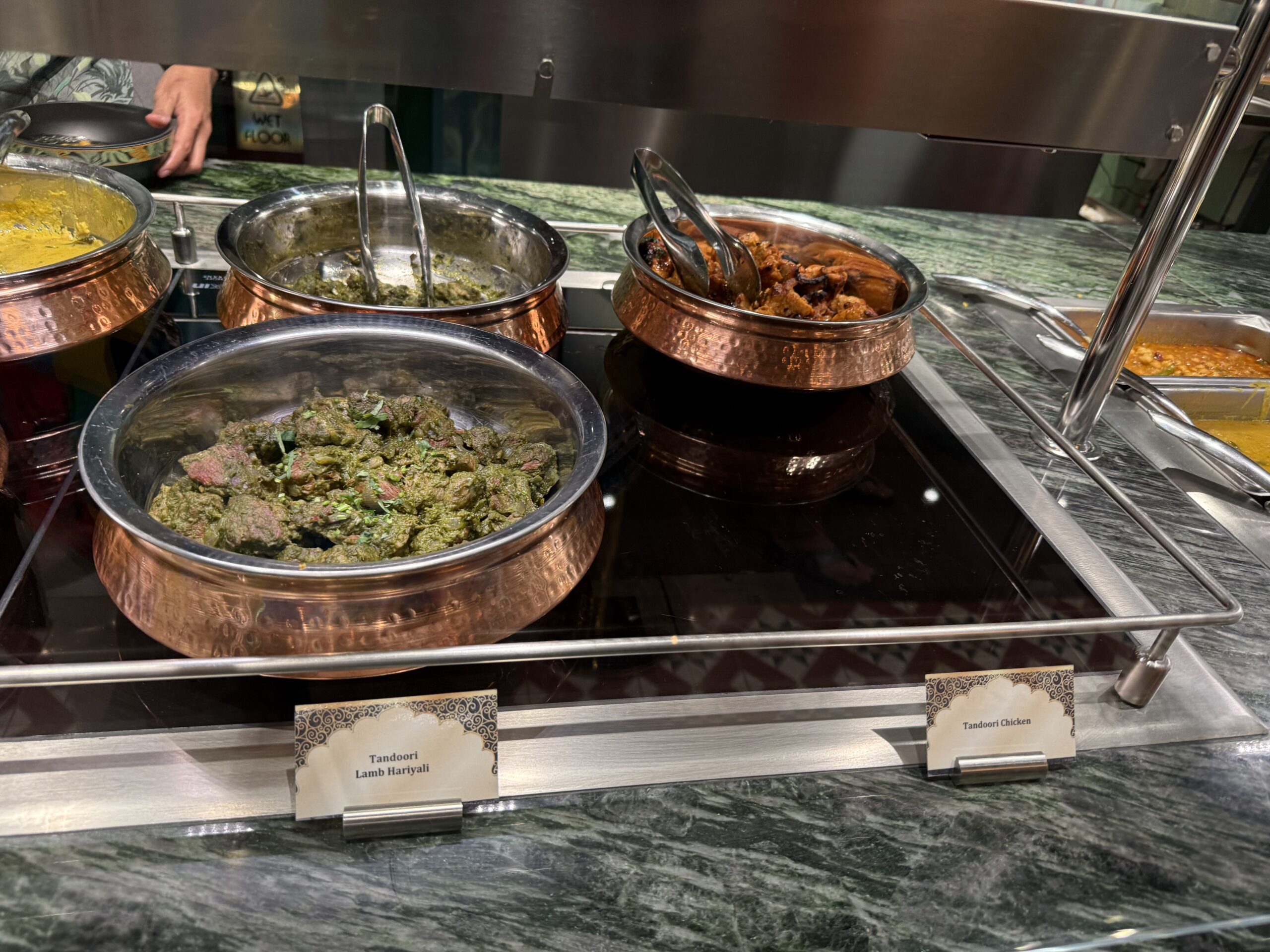 The menu consists of Tandoori Chicken, Tandoori Lamb Hariyali, Butter Chicken, Kerala Fish Curry, and Tandoori Vegetable Momos.