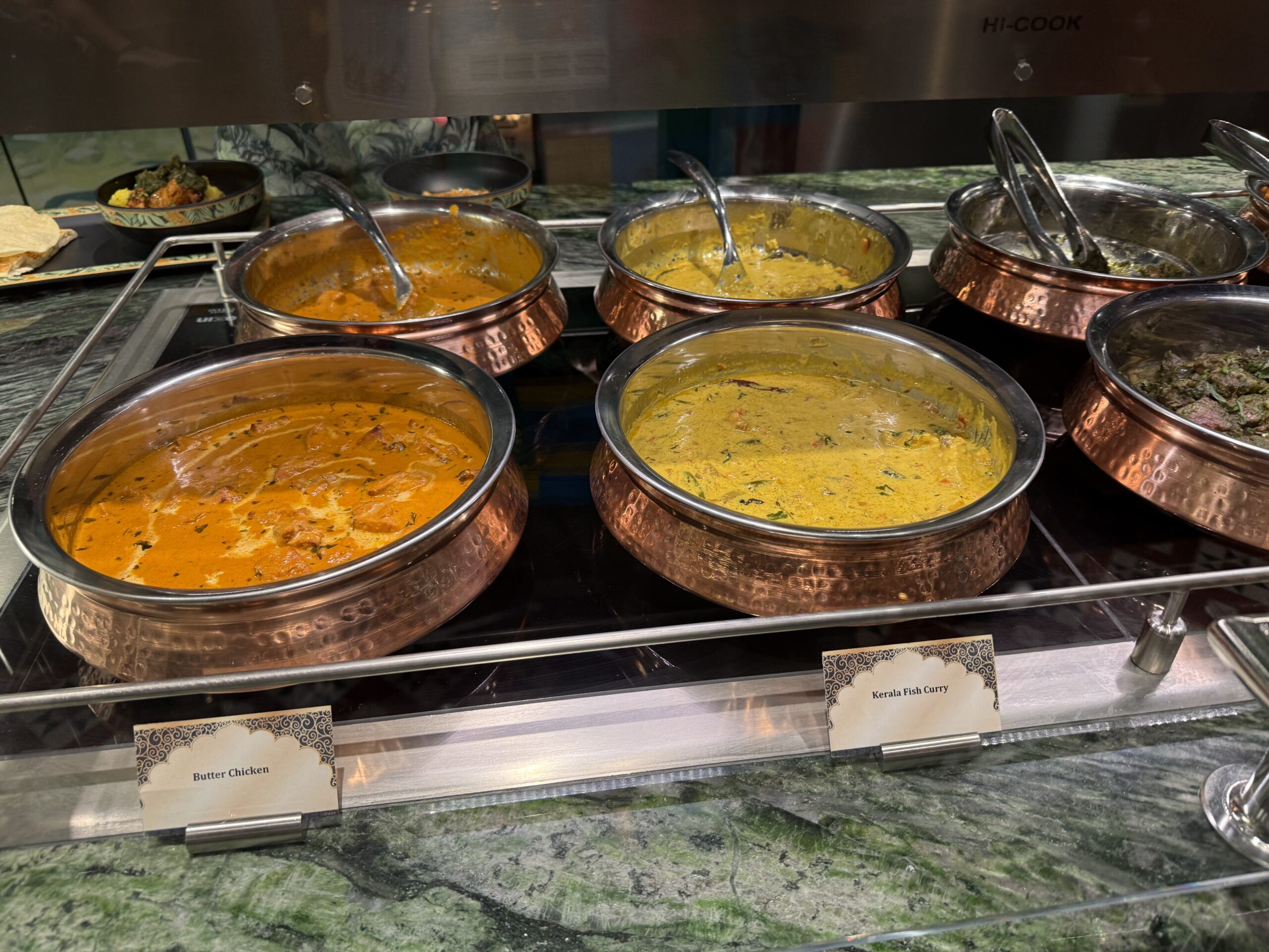 The menu consists of Tandoori Chicken, Tandoori Lamb Hariyali, Butter Chicken, Kerala Fish Curry, and Tandoori Vegetable Momos.