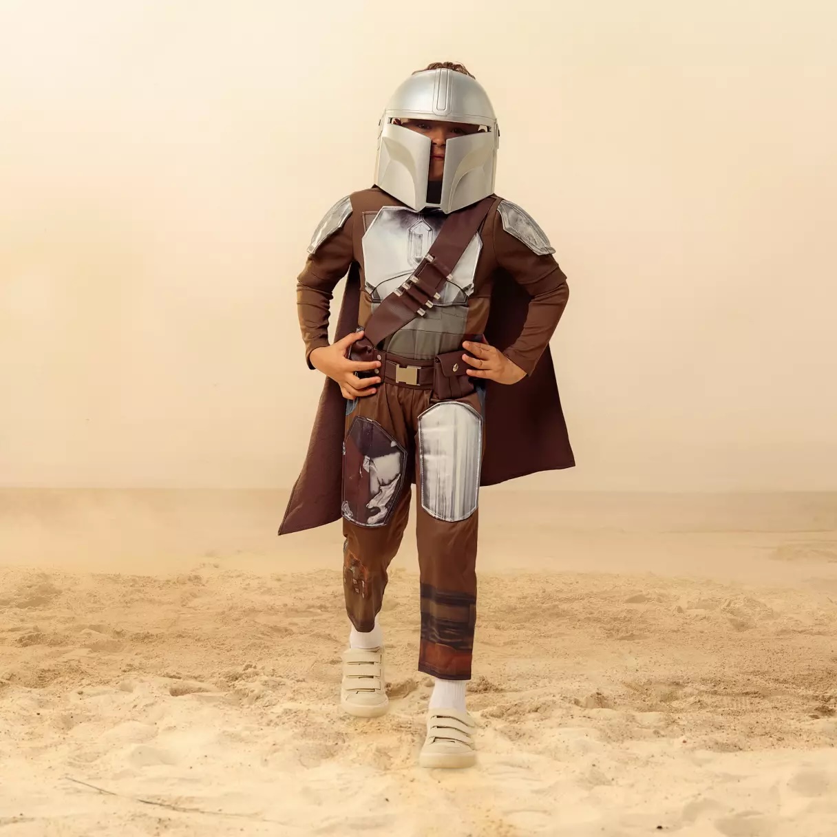 Kids can be the Mandalorian this Halloween (or any time of year) with this set. Includes a bodysuit, belt, cape, and helmet mask. The bodysuit has a simulated suede tunic and metallic simulated leather chest with shoulder armor panels. Velcro closures are on the back.