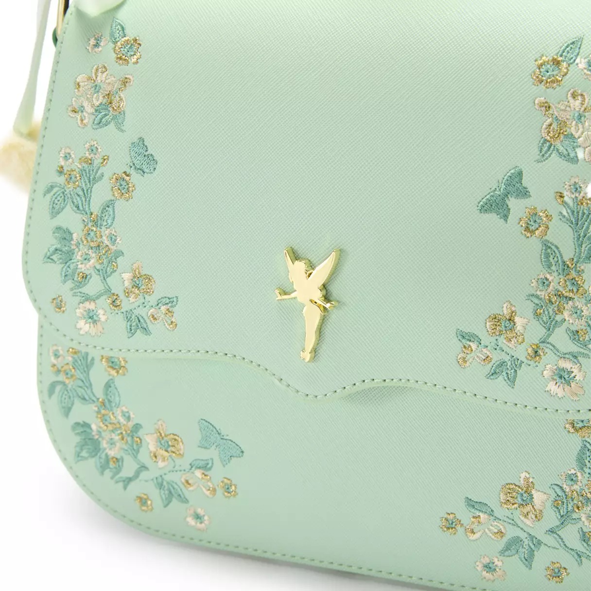 The bag is made of pale green textured simulated leather. The adjustable and removable strap is a brighter green. Embroidered floral and butterfly filigree is on the front and back of the bag.