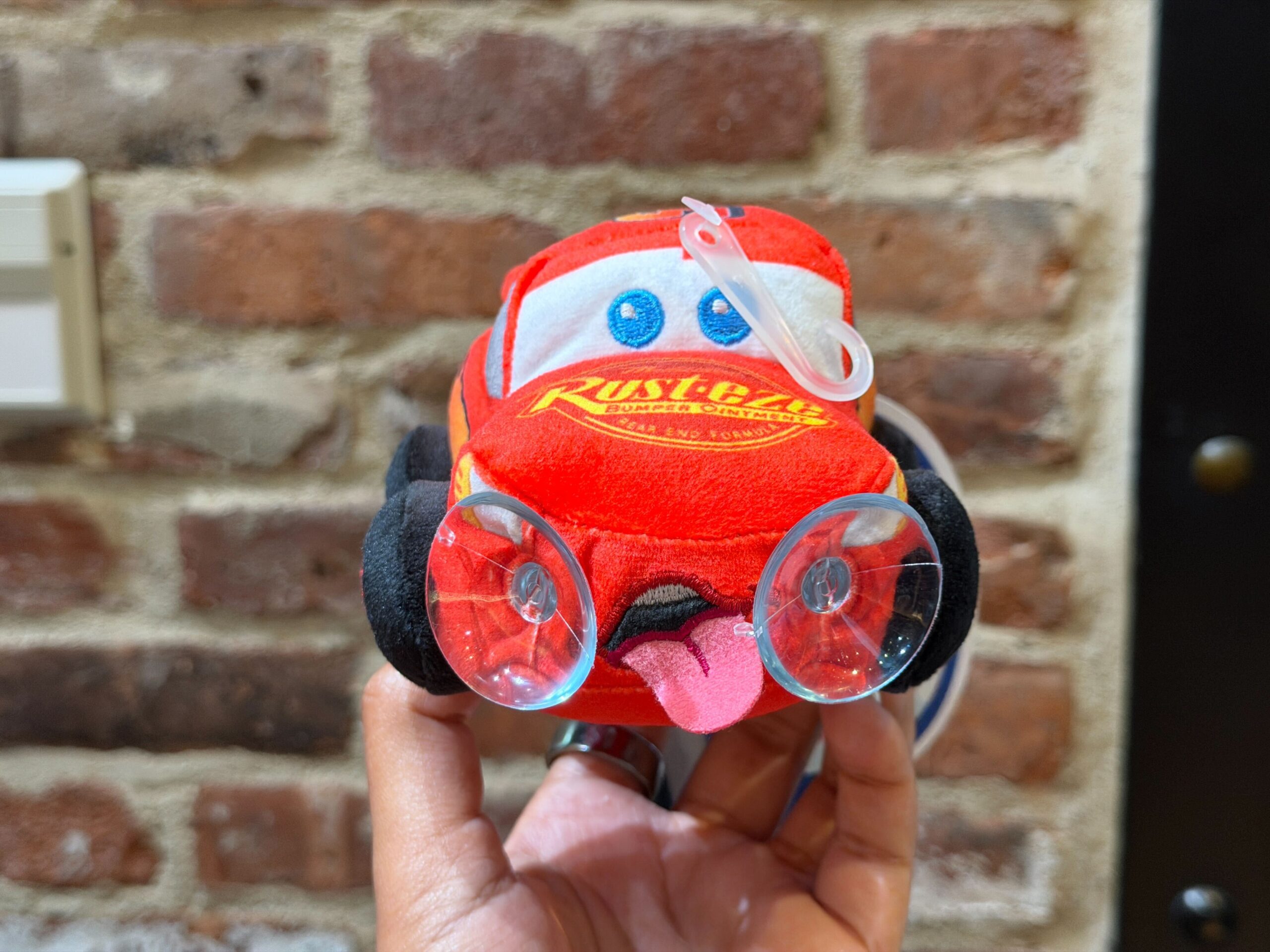 This Lightning plush clings to glass like a car window with two suction cups. Lightning is depicted with his tongue out like he's exhausted from racing.