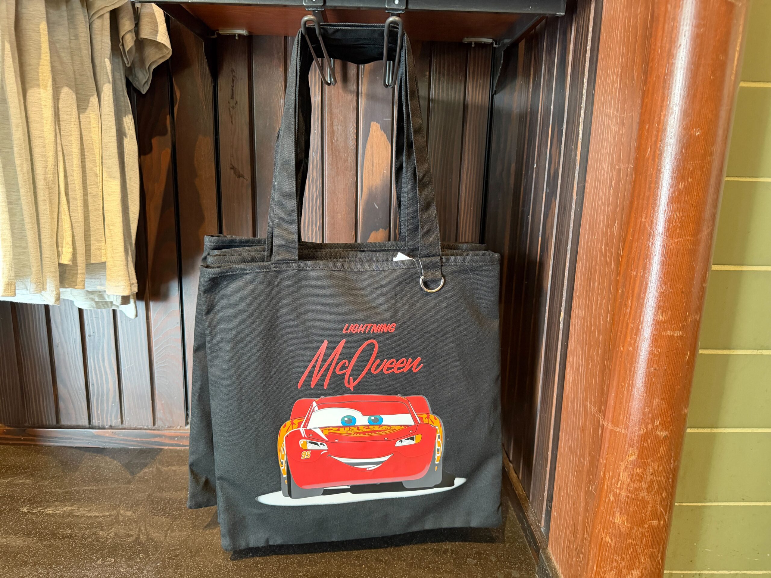 This black tote features a grinning Lightning McQueen with his name on the front. It has two shoulder straps and a ring for bag charms.