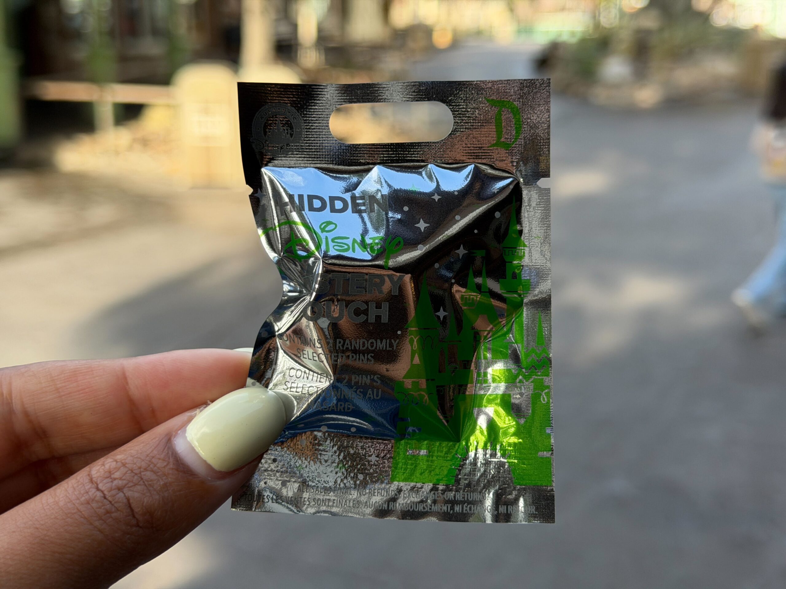 The latest mystery pin pouch has green detailing. Each pouch comes with four random mystery pins.