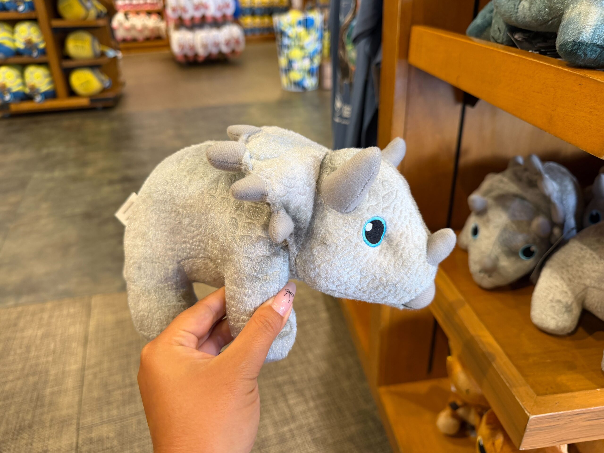 Each plush depicts a different species of dinosaur with a soft body, three-dimensional features, and embroidered eyes and mouths.