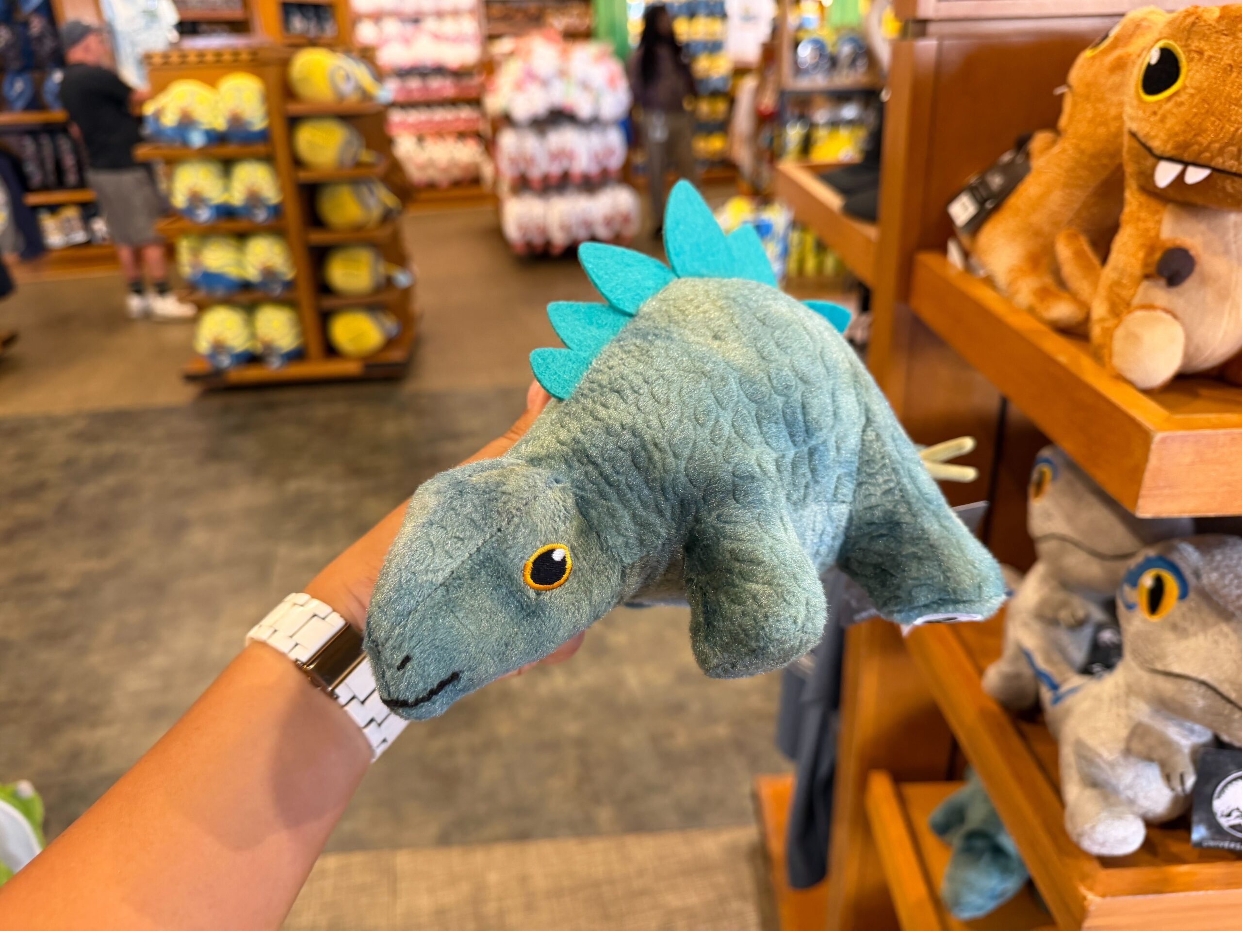Each plush depicts a different species of dinosaur with a soft body, three-dimensional features, and embroidered eyes and mouths.
