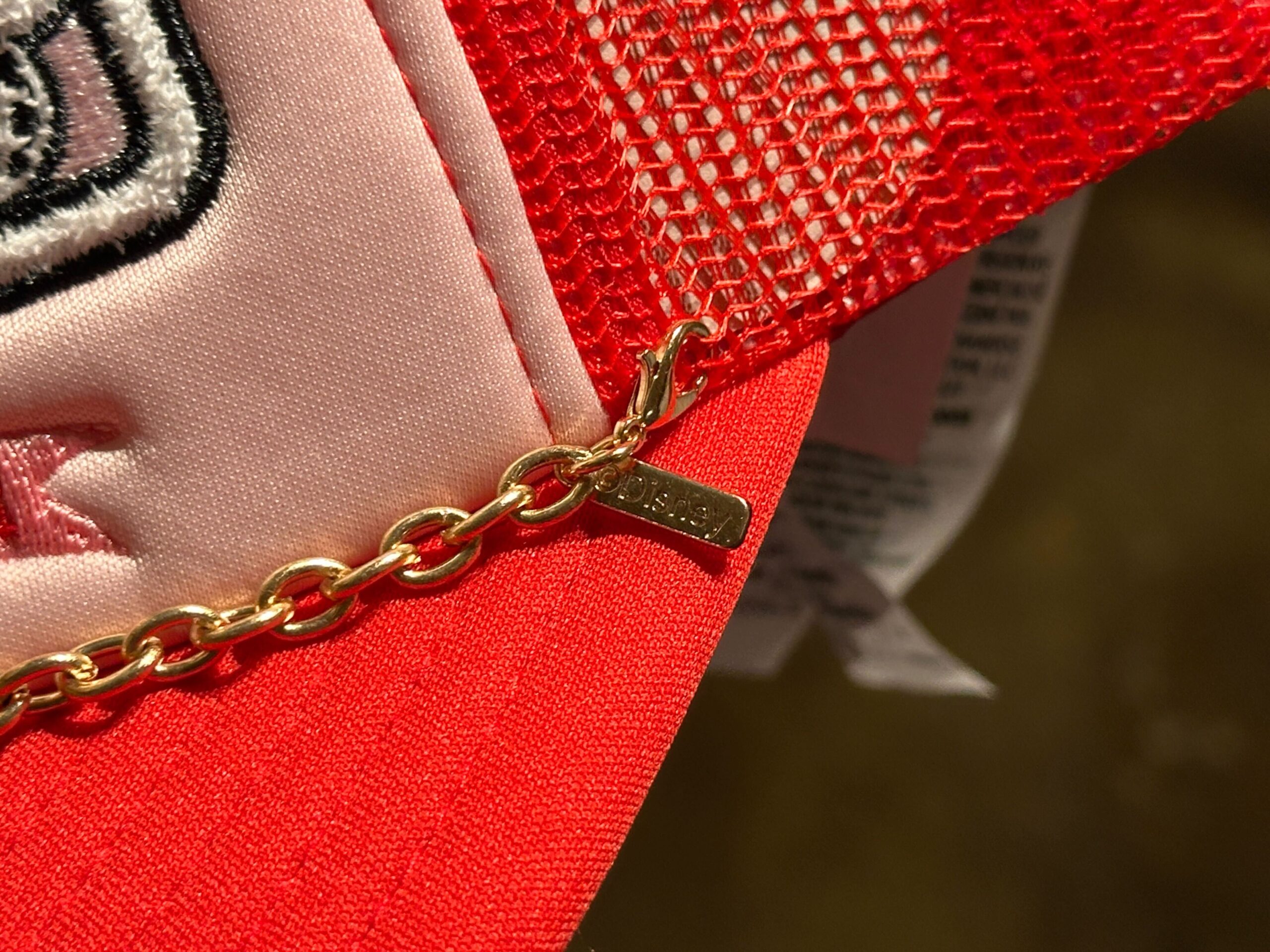 Close-up of chain on the front of the Disney World Icons Red Trucker Hat.