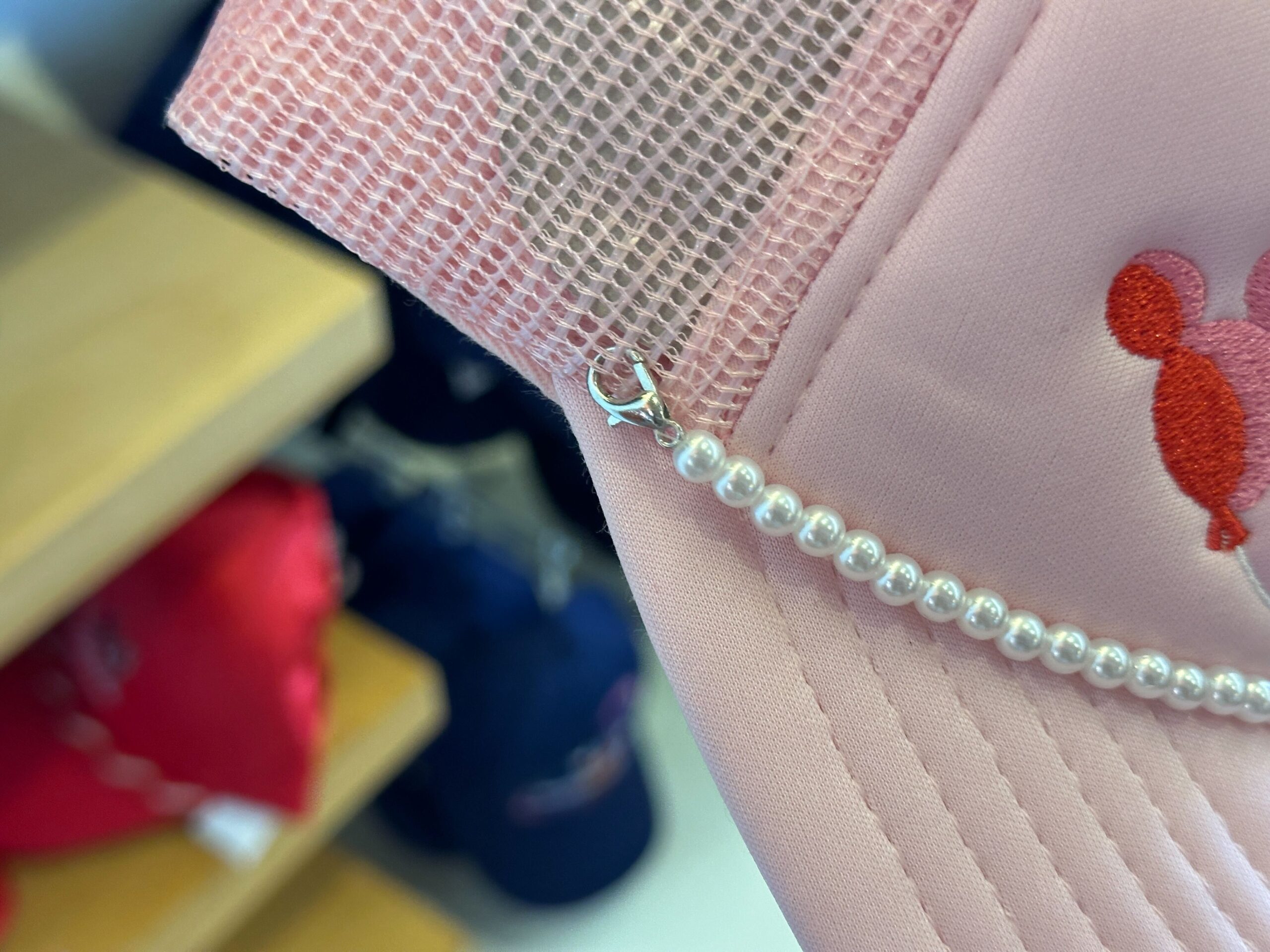 Close-up of pearls on the front of the Disney World Icons Pink Trucker Hat.