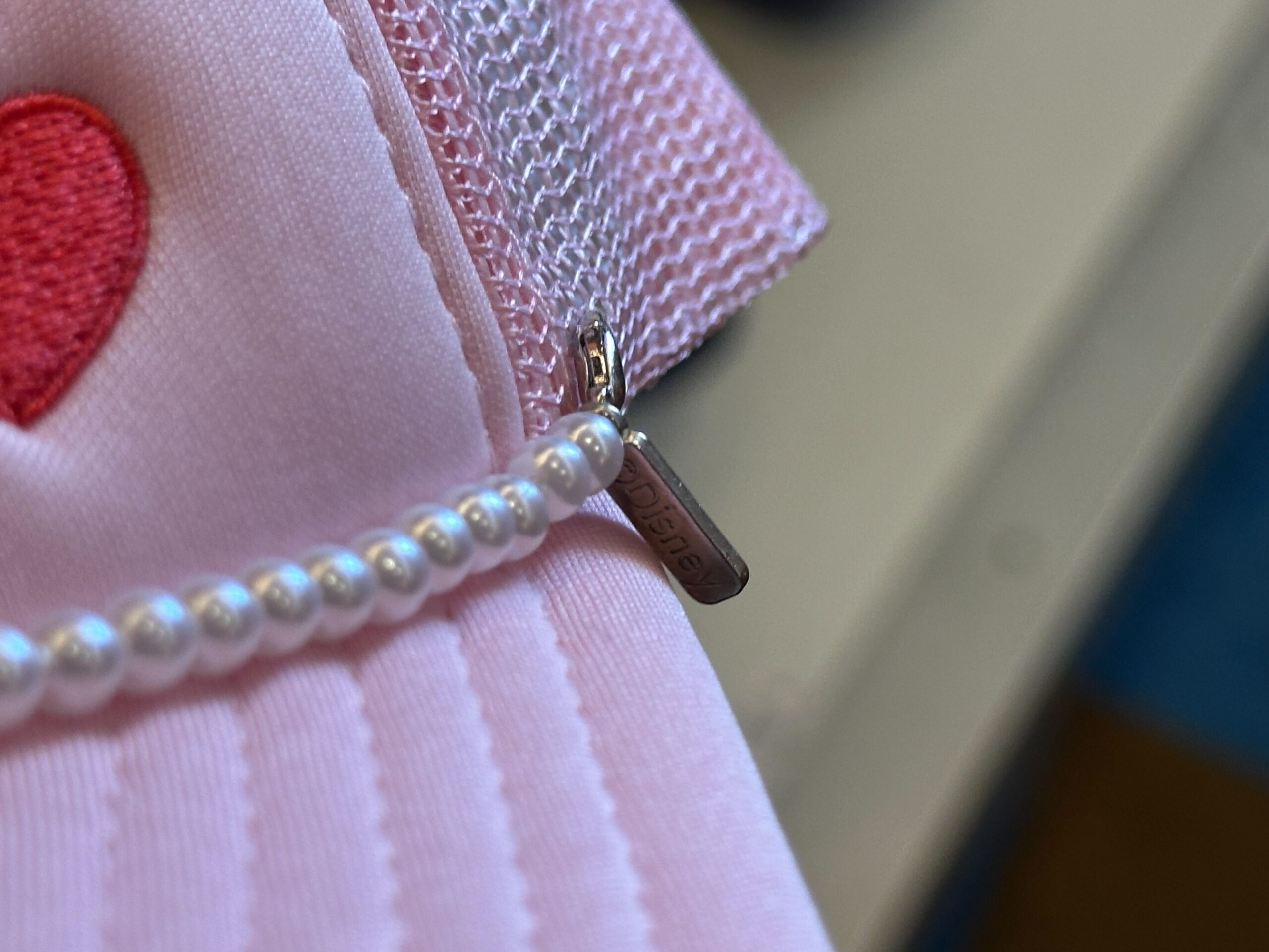 Close-up of pearls on the front of the Disney World Icons Pink Trucker Hat.