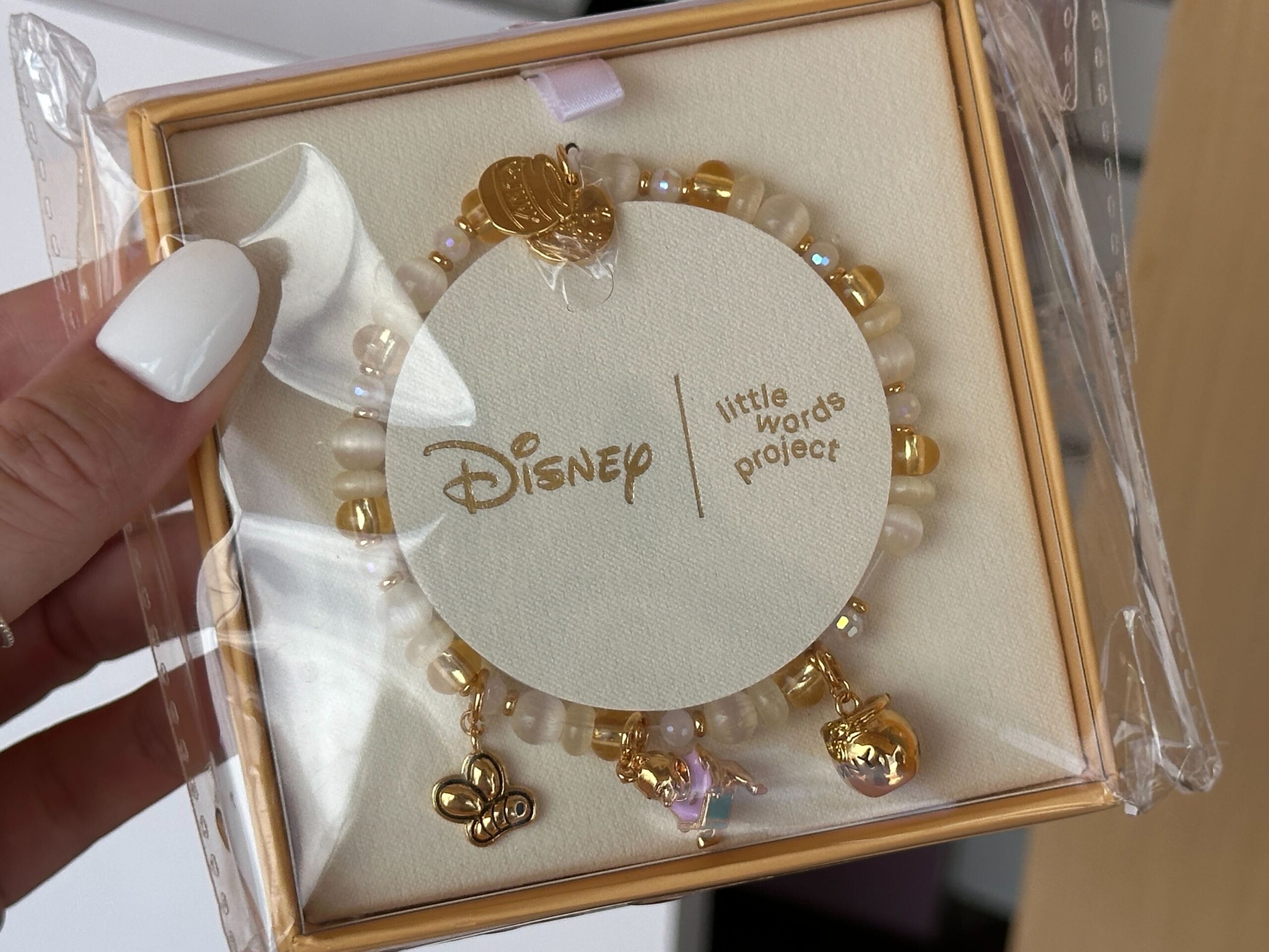 This charm bracelet offers a subtle touch of Pooh with three non-removable charms (the same as the individual charms seen above). It comes in several sizes and is adorned with ivory, gold, and translucent beads throughout.