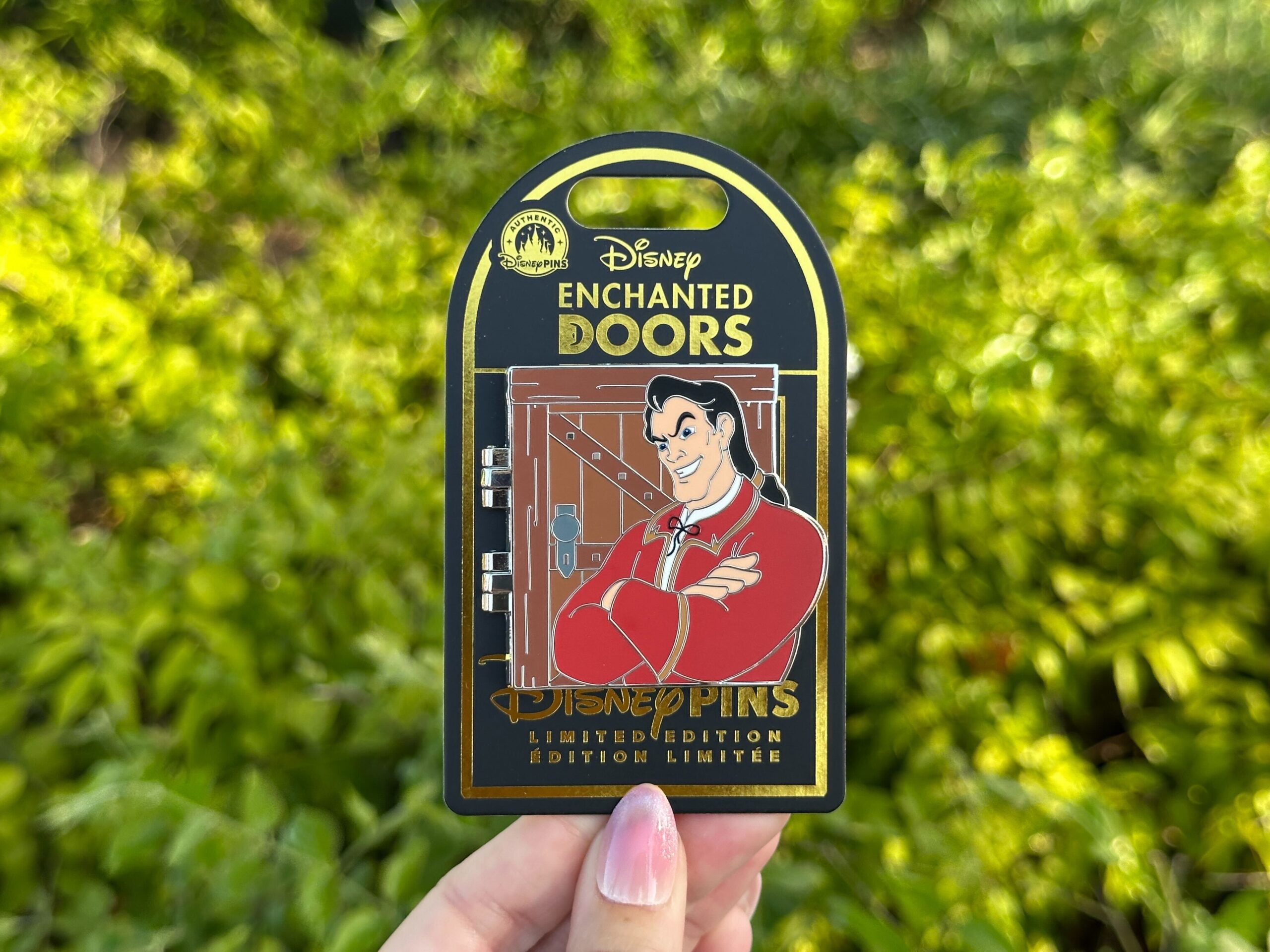 The new "Enchanted Doors" pin depicts Gaston at Belle's front door. It opens to show him talking to her inside the cottage. It's limited edition of 2,500.