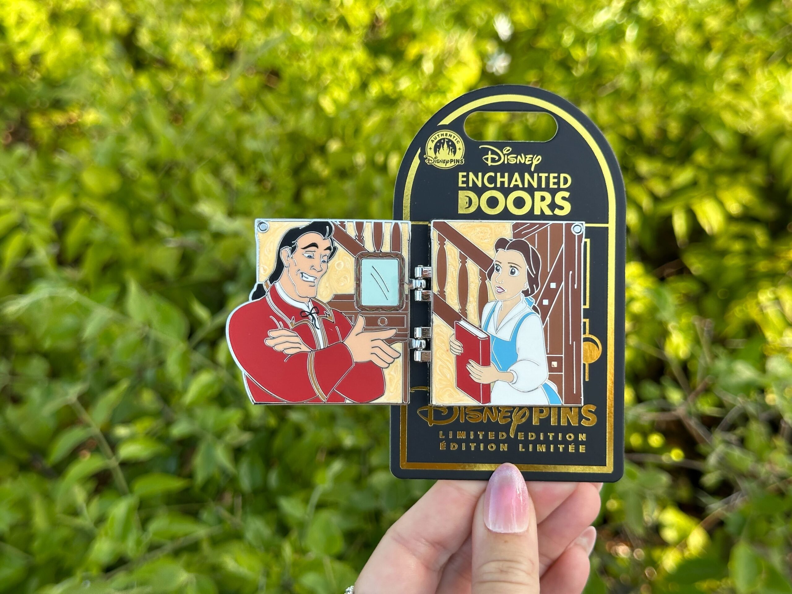The new "Enchanted Doors" pin depicts Gaston at Belle's front door. It opens to show him talking to her inside the cottage. It's limited edition of 2,500.