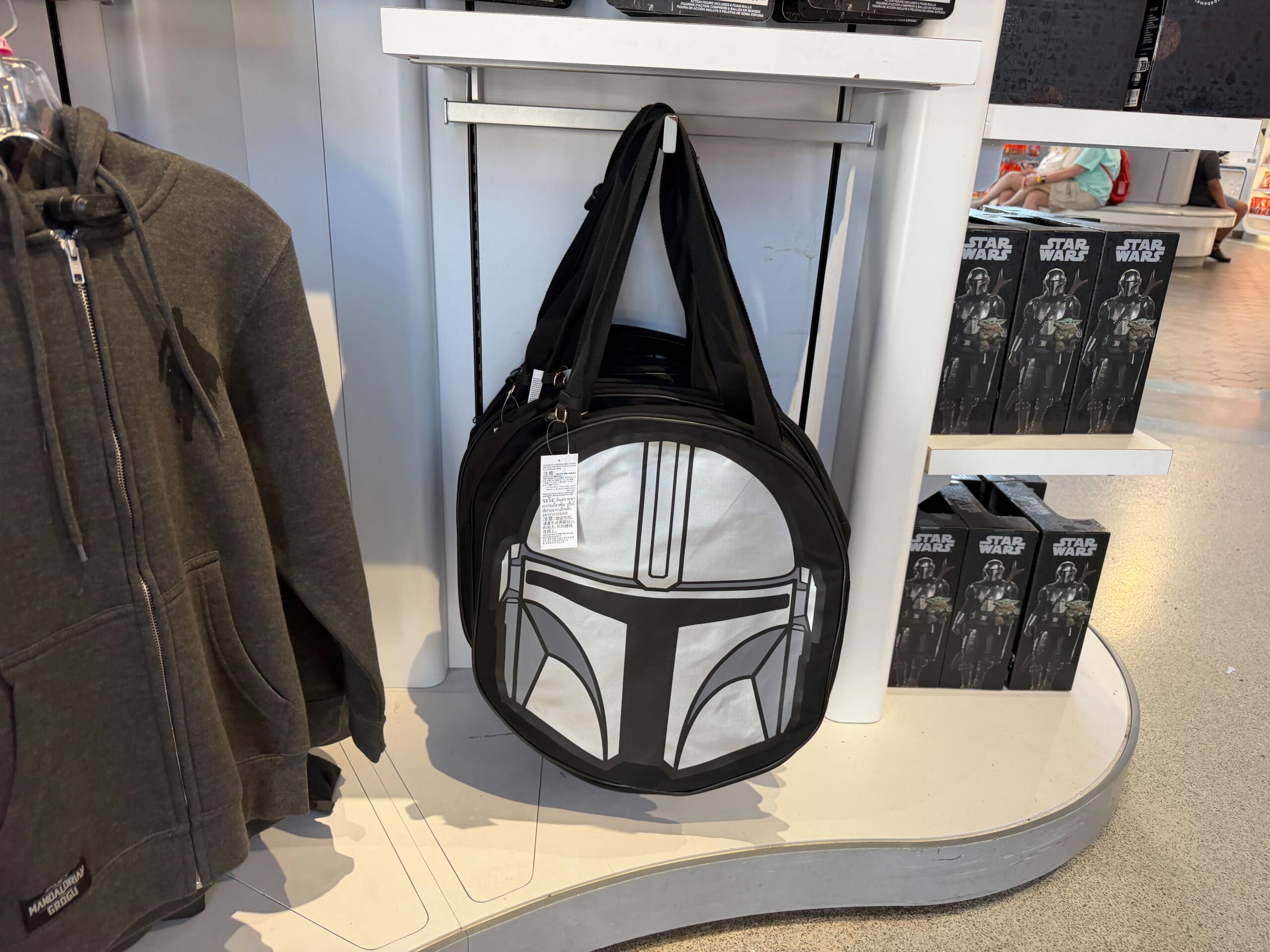This black canvas tote features a printed image of Mando's silver helmet on the front. On the back is the film's logo and "This is the way."