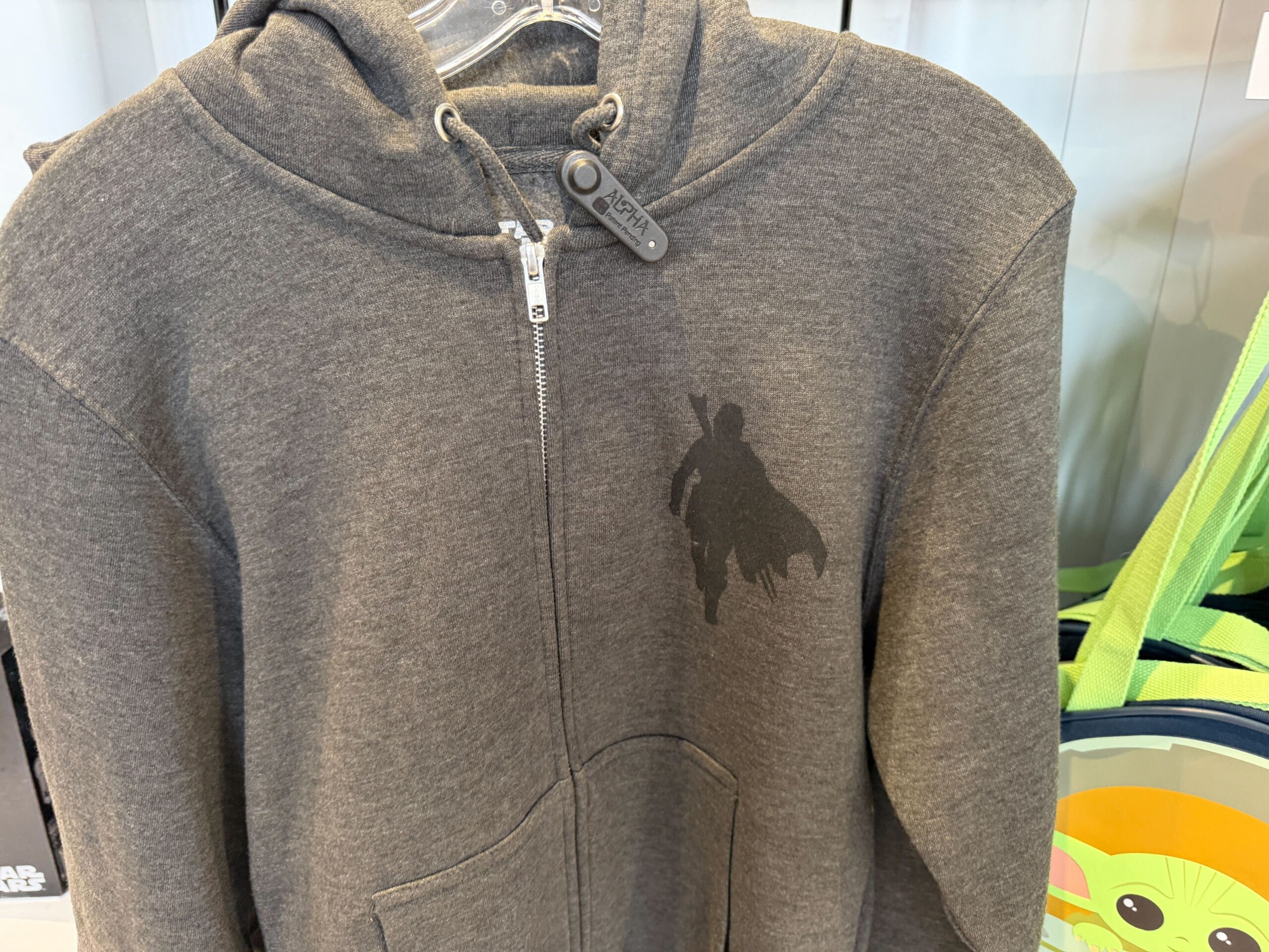 This is a dark heather gray hoodie. On the left chest is the silhouette of the Mandalorian with his cape.