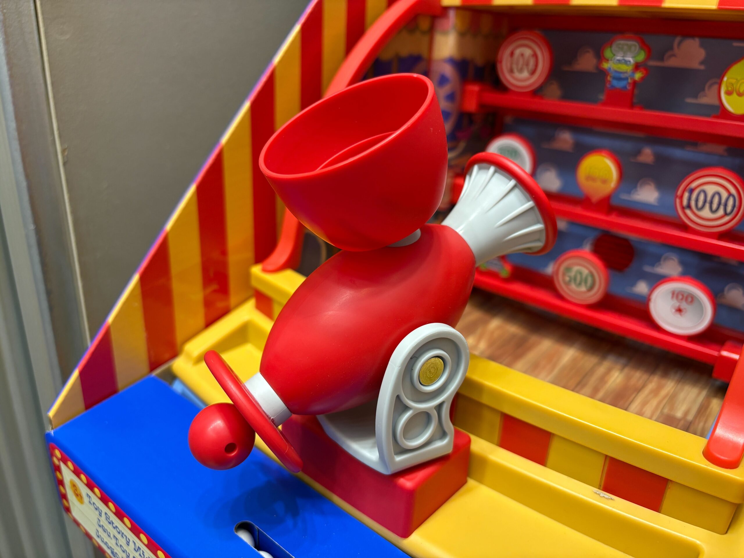 The shooter has a pull cord just like those on the ride. There's a bucket on top to hold the 10 included balls.